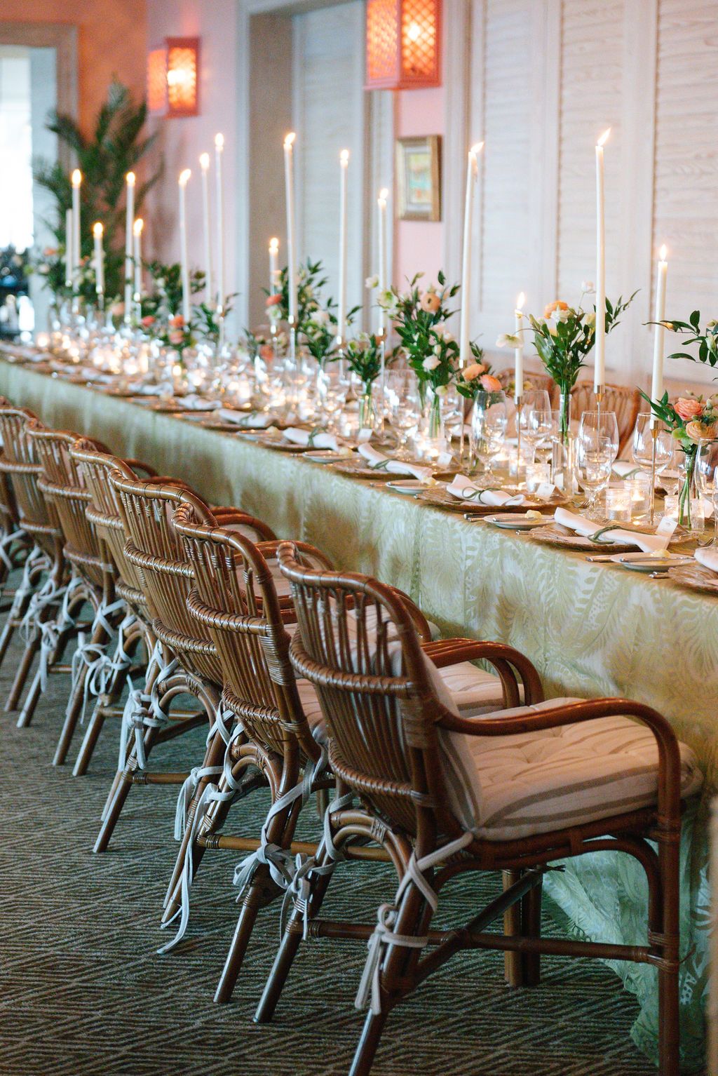 Long banquet table with wooden chairs and elegant place settings for a formal event.