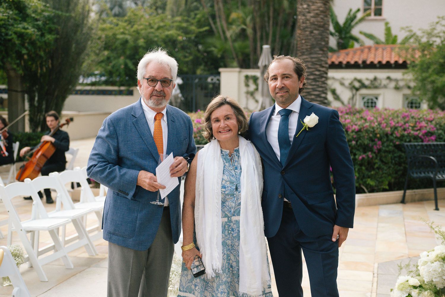Wedding guests in formal attire mingling during an outdoor reception.