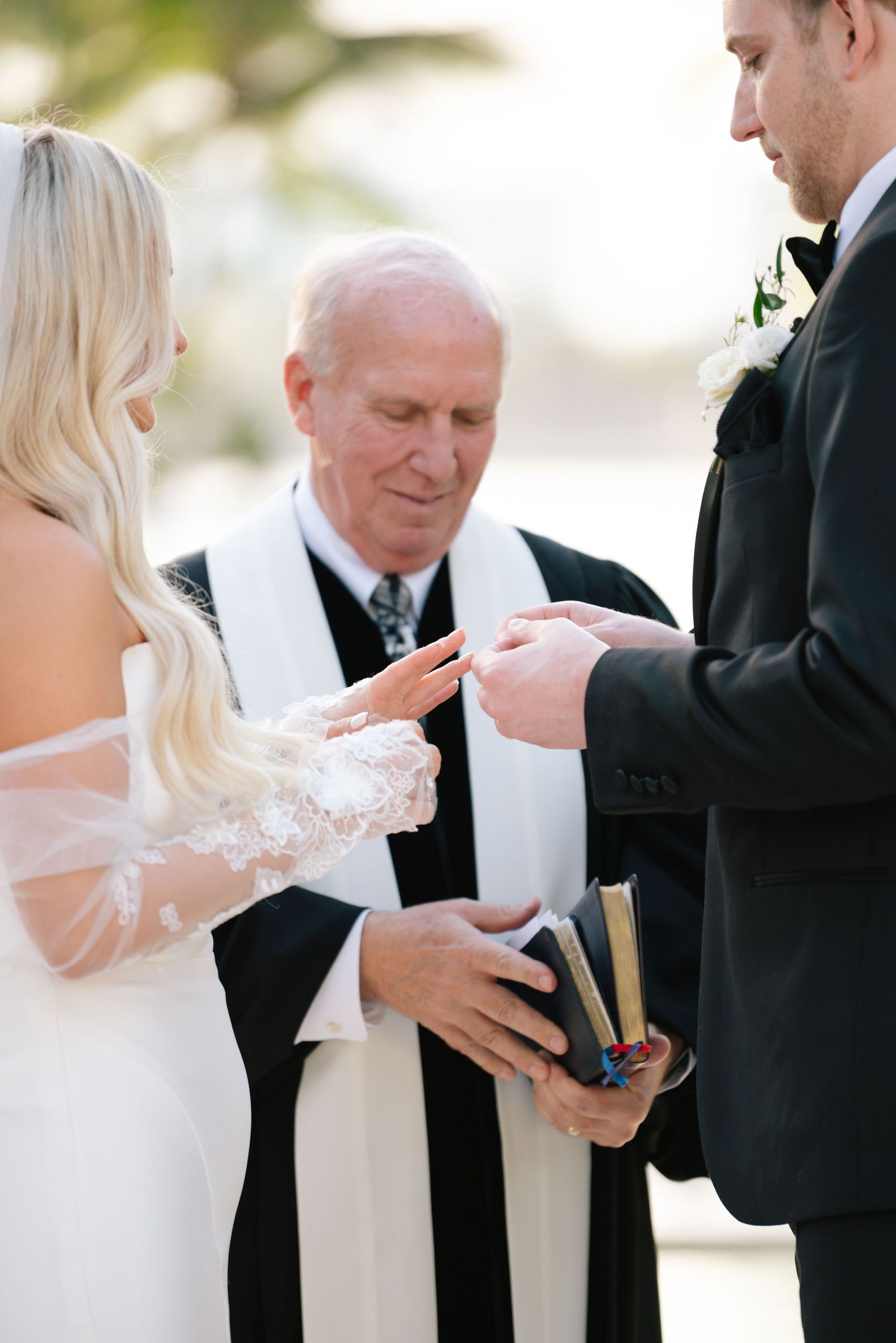 Wedding ceremony detail shots showing hands during ring exchange.