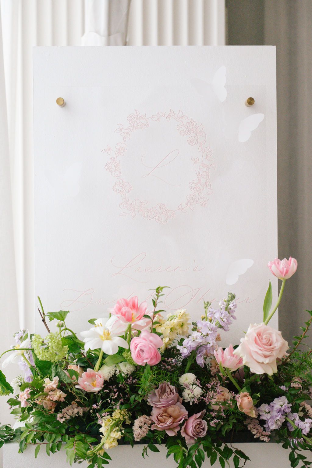 Beautiful floral arrangement with pink roses and mixed flowers adorning a white backdrop.