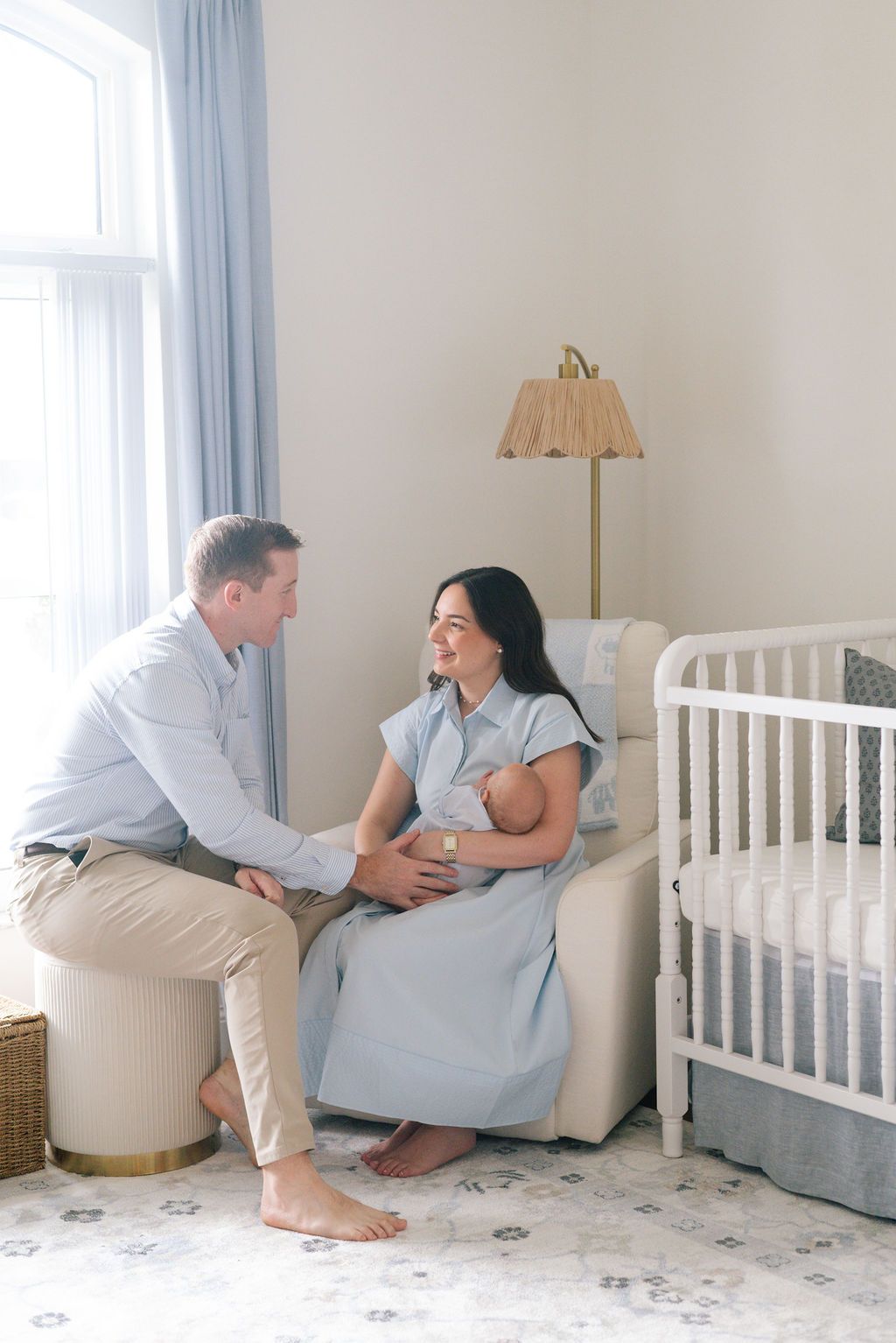 Family photoshoot in a serene nursery with white and blue decor.