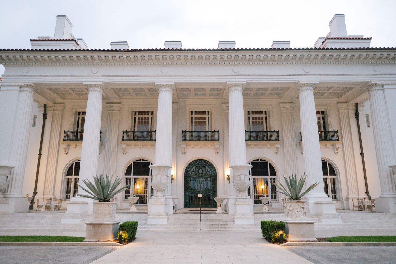Classical white colonial building exterior with columns and arched windows in elegant architectural style.