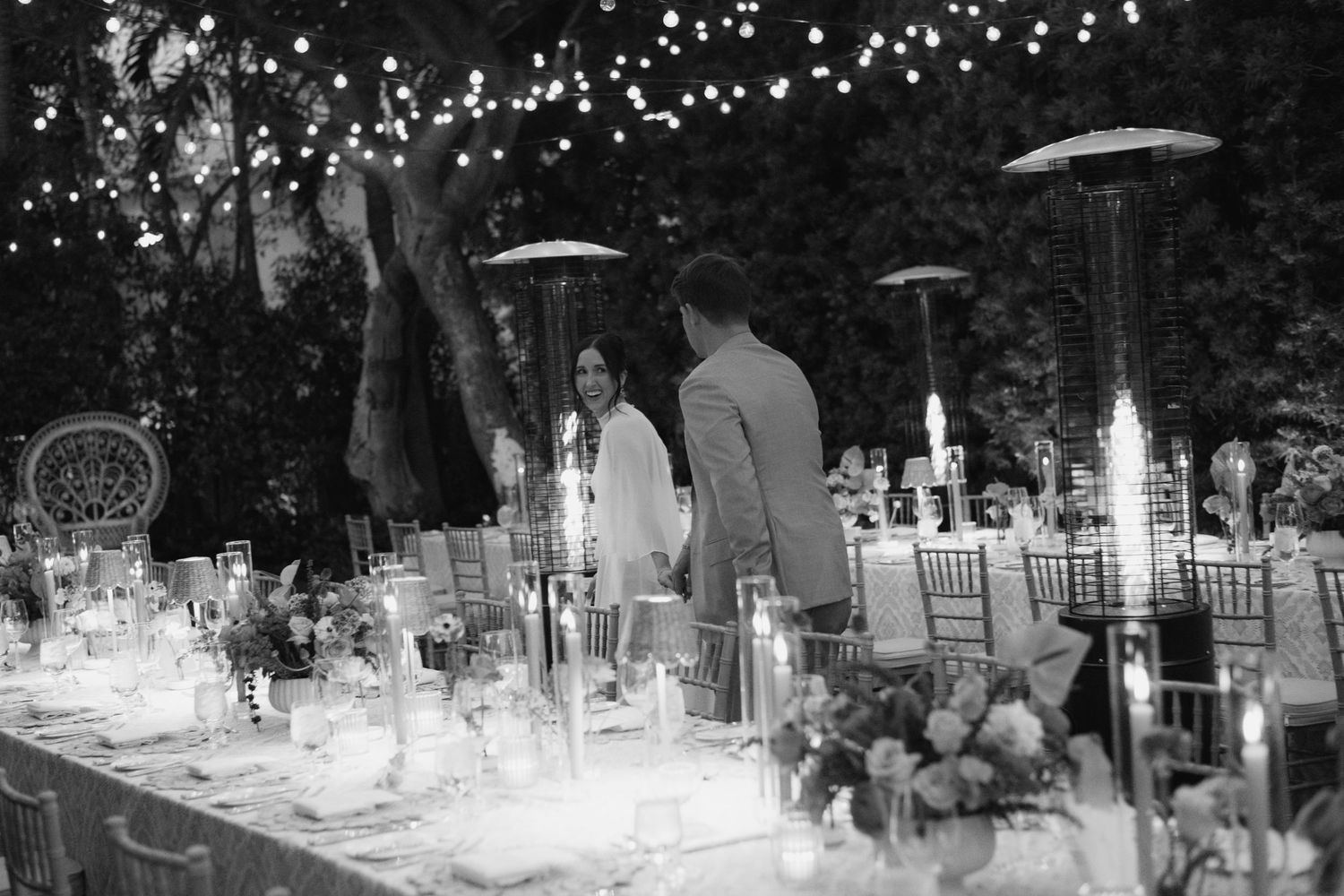 Outdoor evening reception with twinkling lights and elegant table settings.