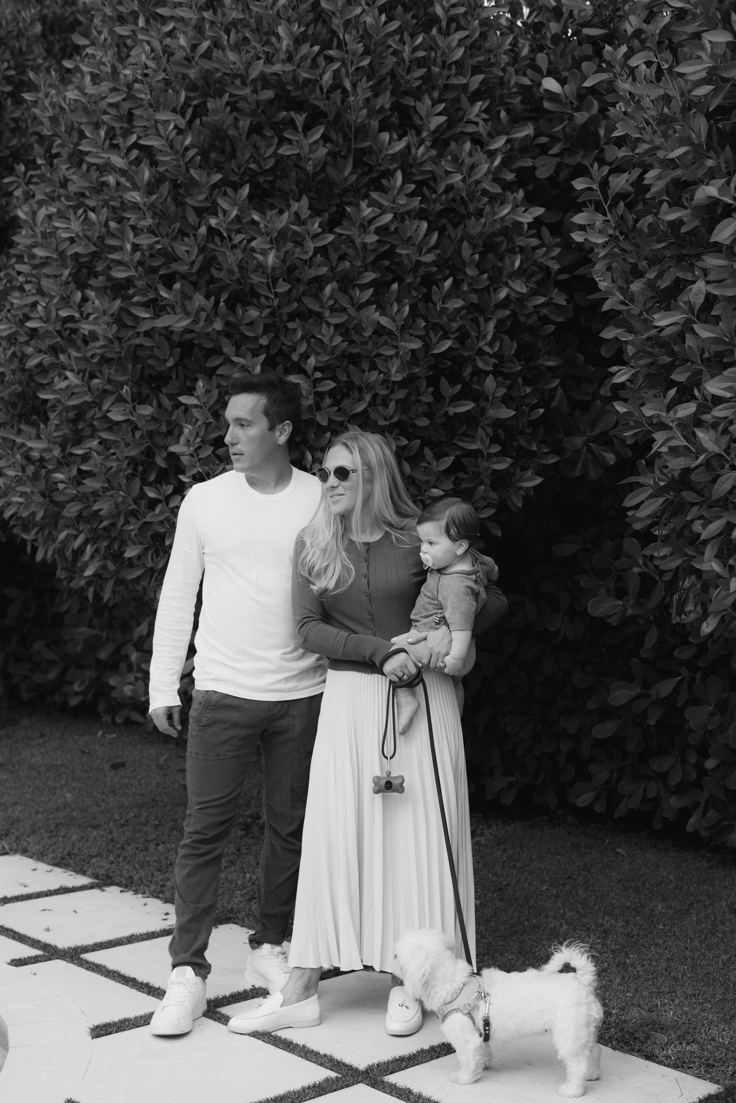 A series of black and white photographs showing a couple dancing together in a garden setting.