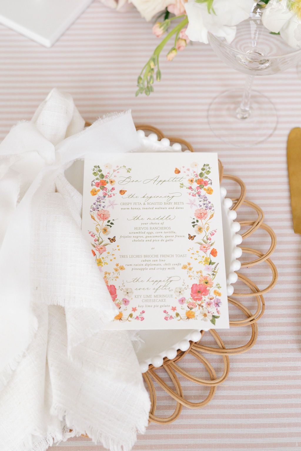 Elegant wedding table setting with floral place cards and white linens.