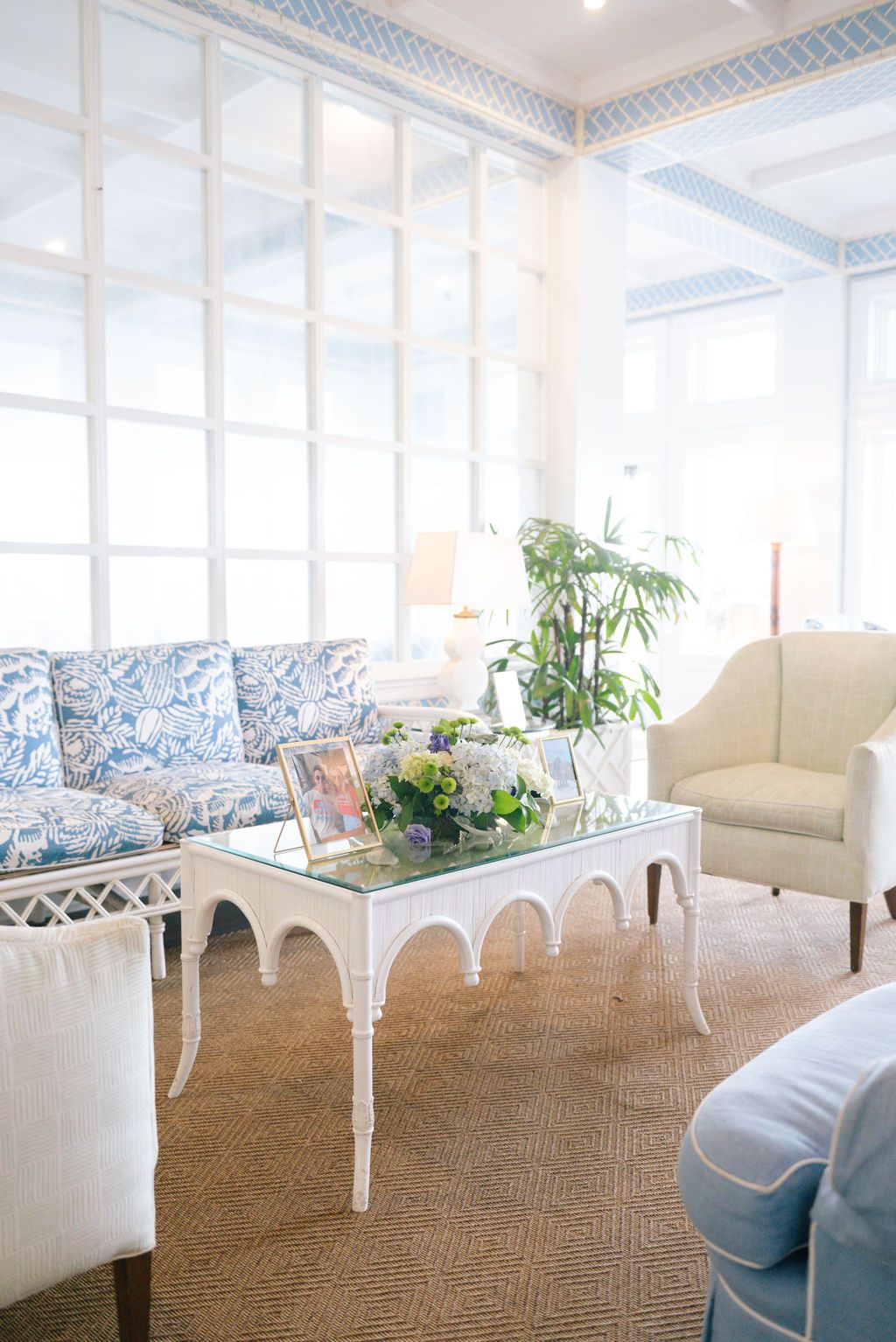 Elegant coastal-style lounge with blue and white furniture and natural lighting.