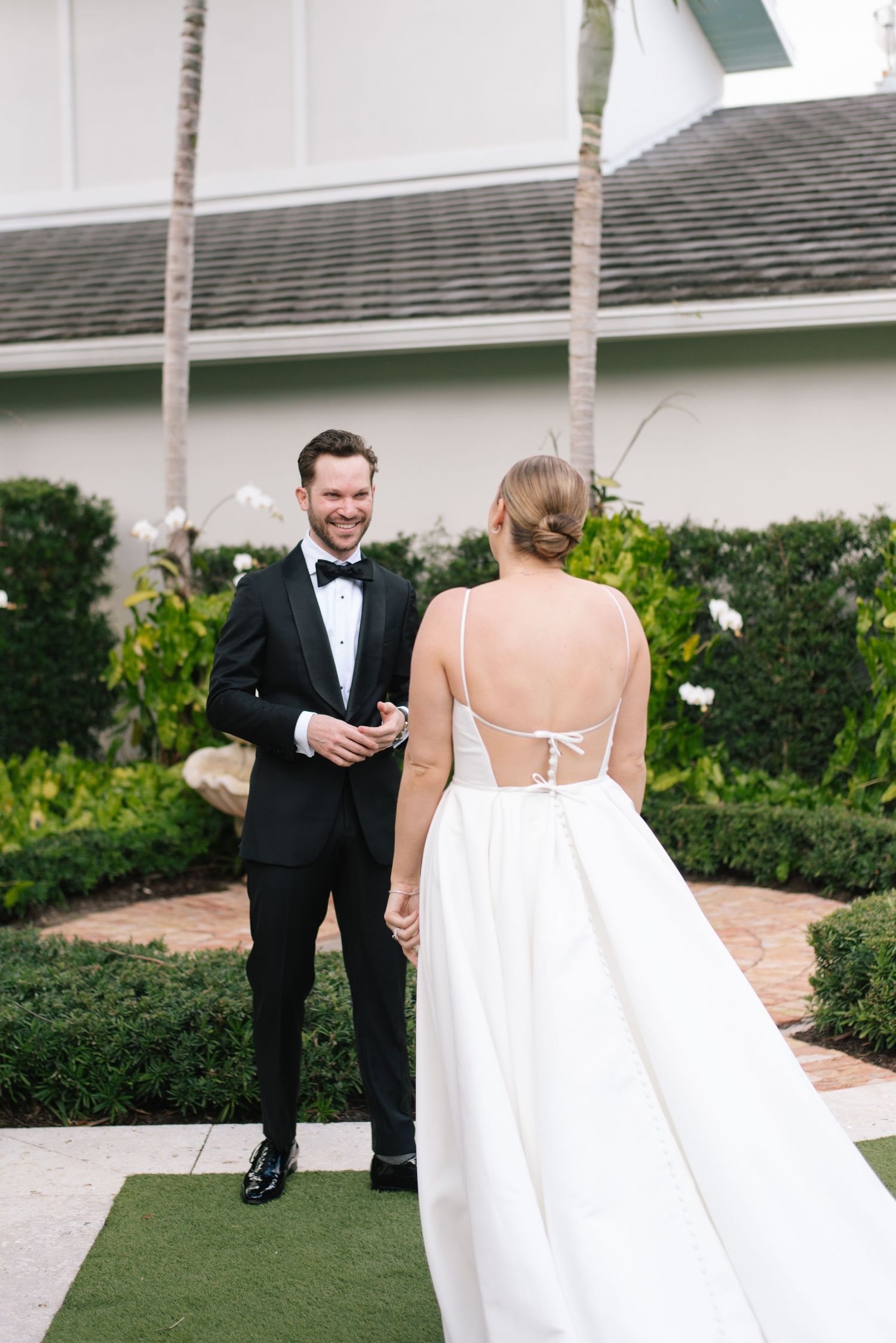 A sweet first look moment between a couple on their wedding day in a garden setting.