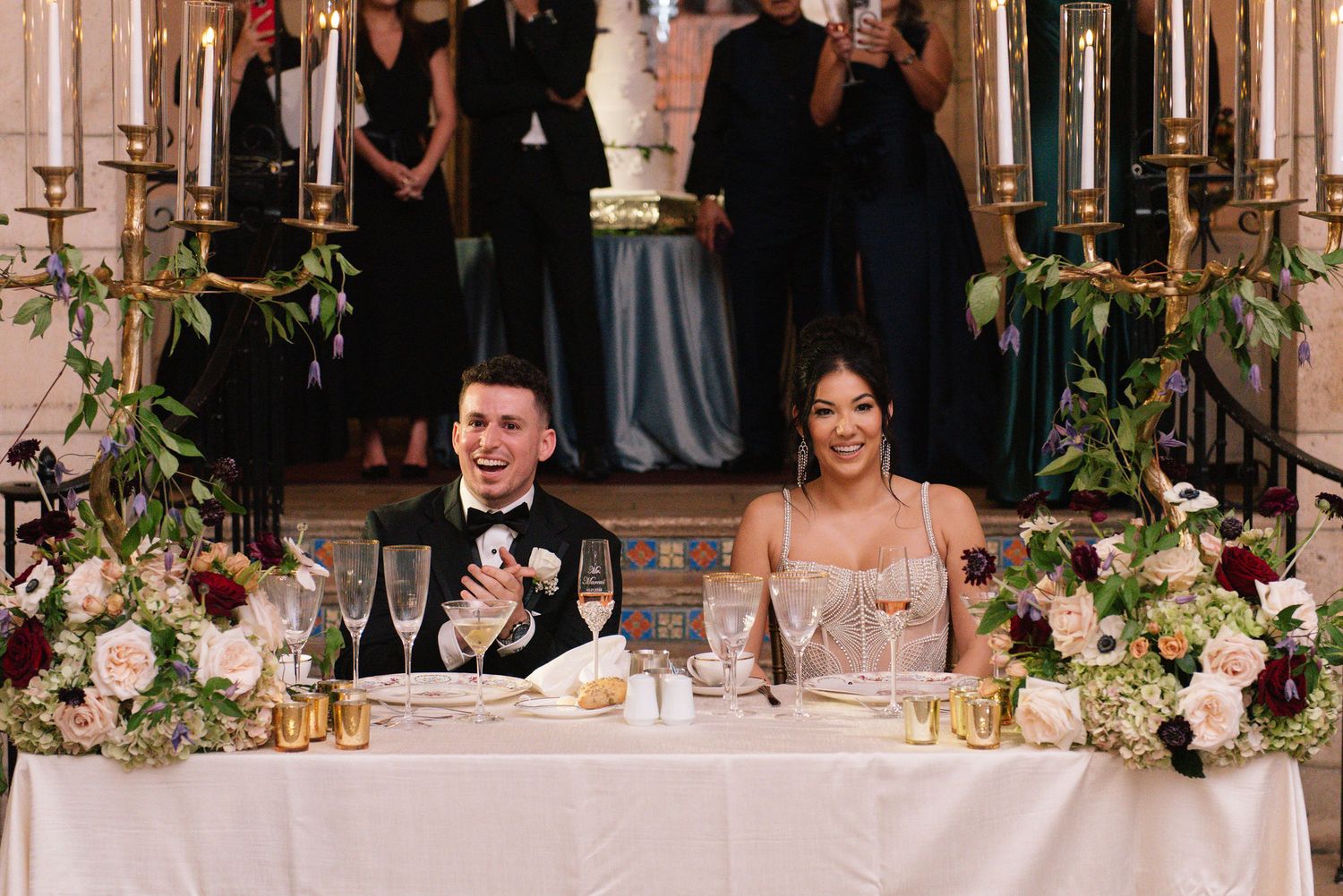 Elegant wedding reception setup with floral arrangements and white decor in a historic venue.