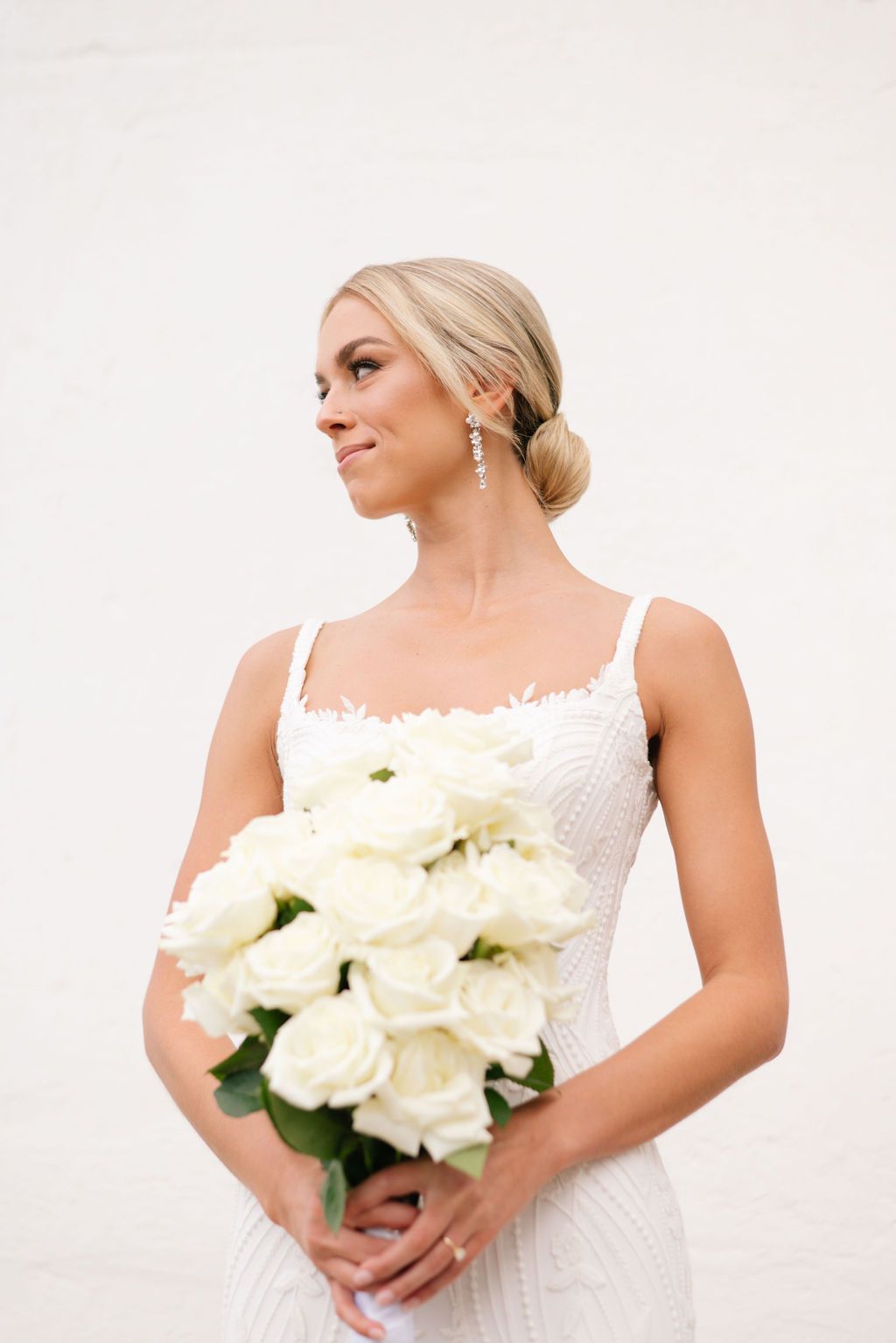 Elegant bridal poses with white rose bouquet in studio setting.