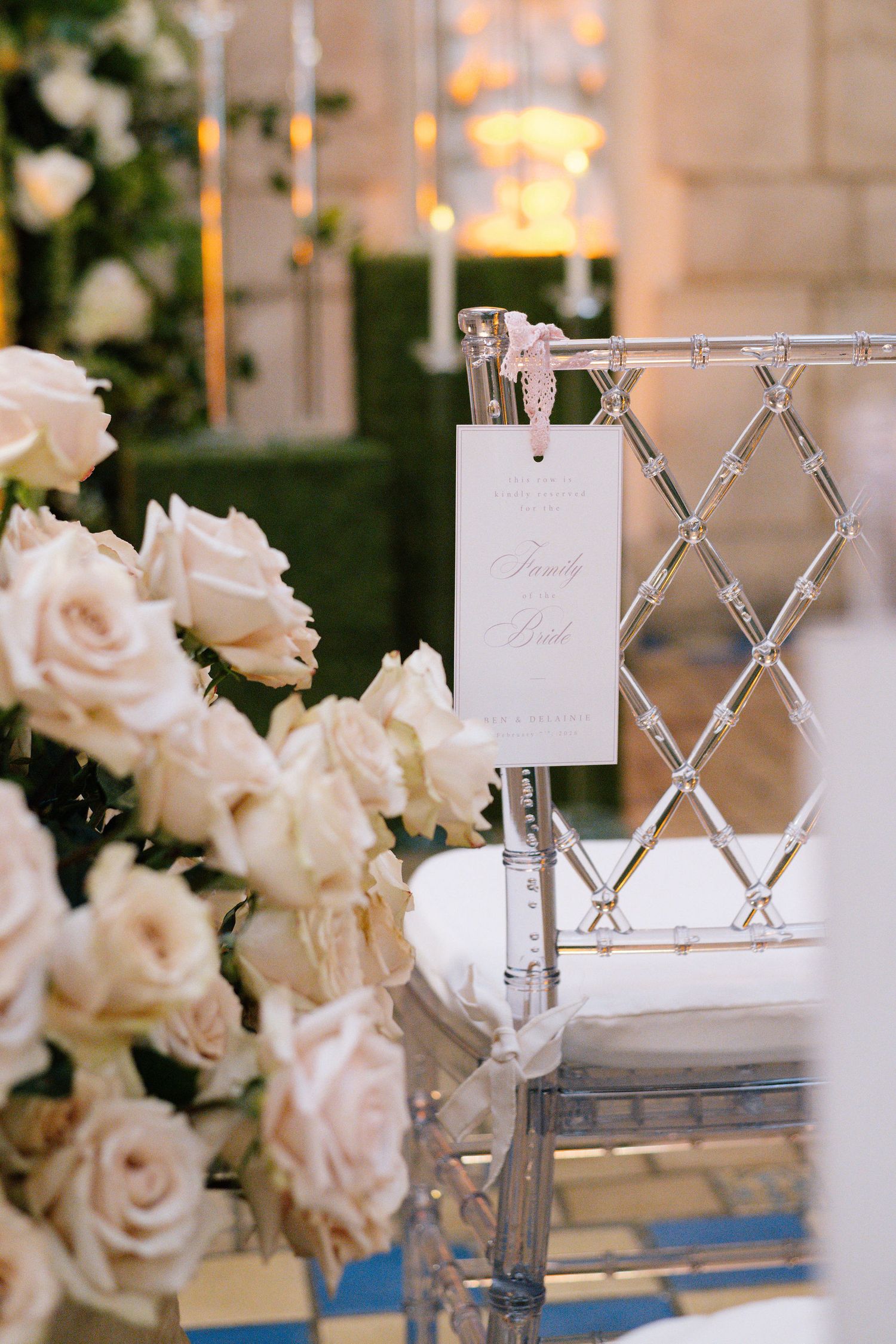 White roses and place cards adorn wedding reception seating with elegant crystal details.