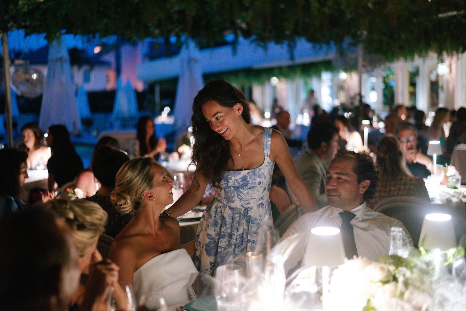 Evening wedding reception with blue ambient lighting and candlelit tables.