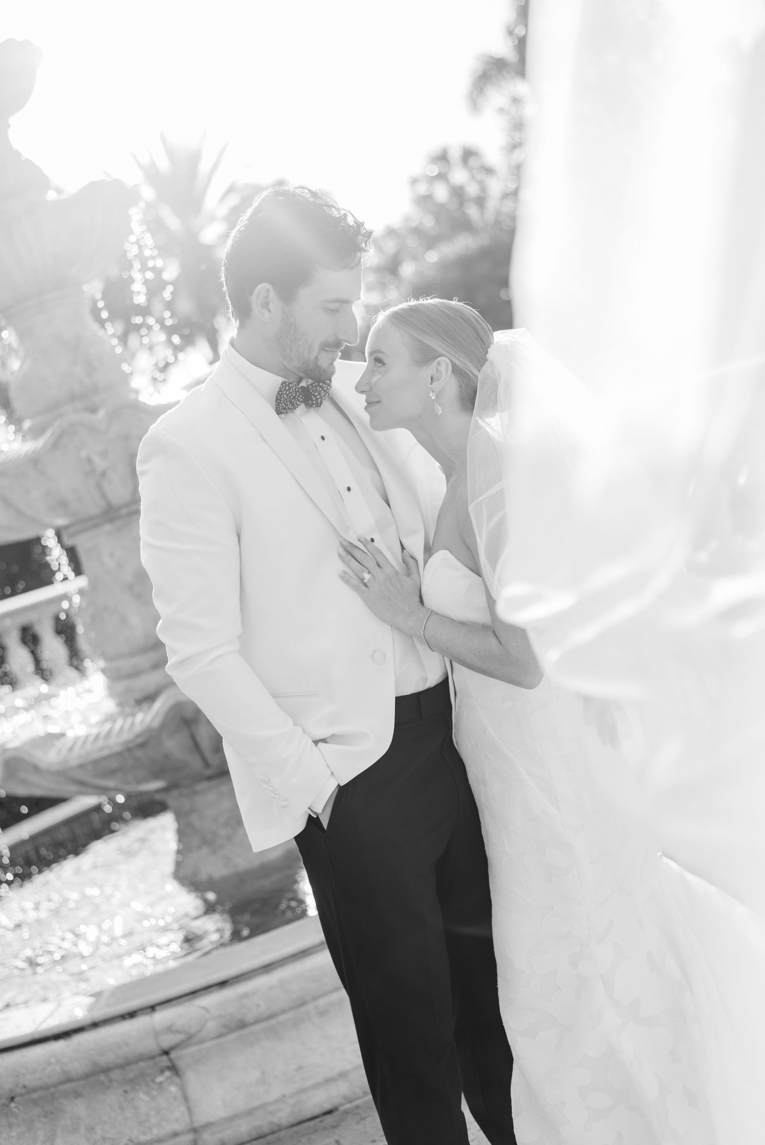 Intimate black and white wedding portraits captured against white architectural backdrop.