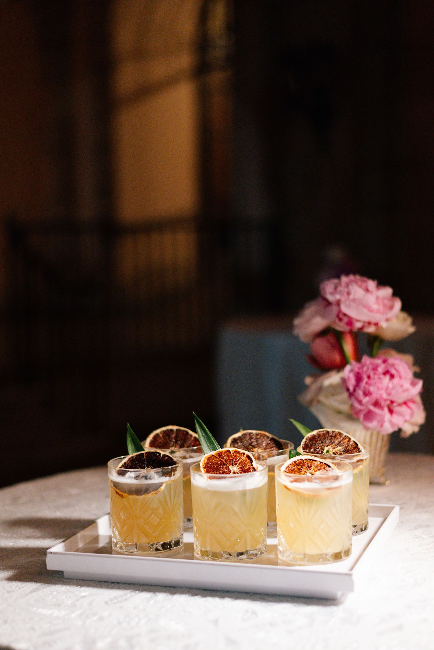 Artfully plated desserts topped with fresh flowers and garnishes on white serving platters.
