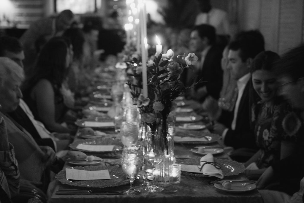 Elegant candlelit dinner table set for formal event with glassware and place settings in black and white.