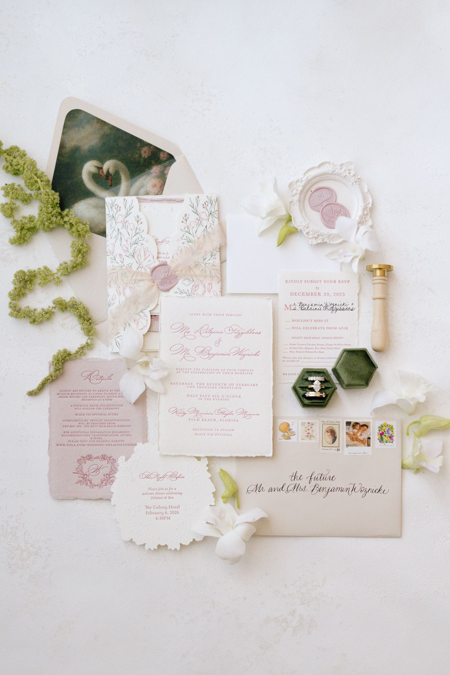 Elegant wedding invitation suite in soft pink and white with ornate details and floral accents.
