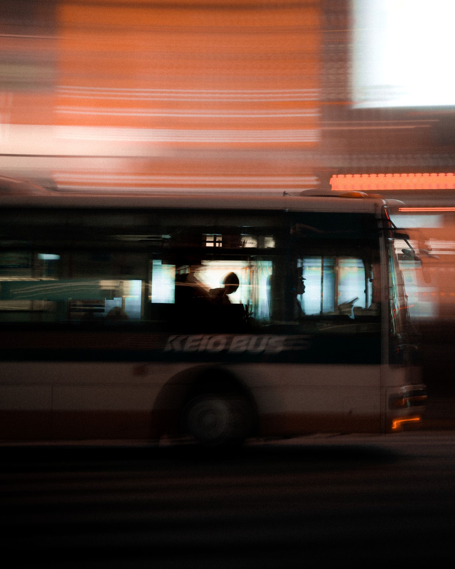 Abstract motion blur photograph shows streaks of orange light against dark background creating a sense of movement.
