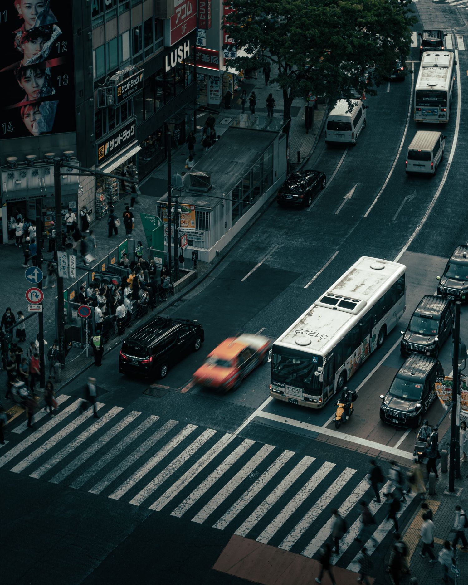 Aerial view of a busy city intersection with crosswalks and traffic during dusk.