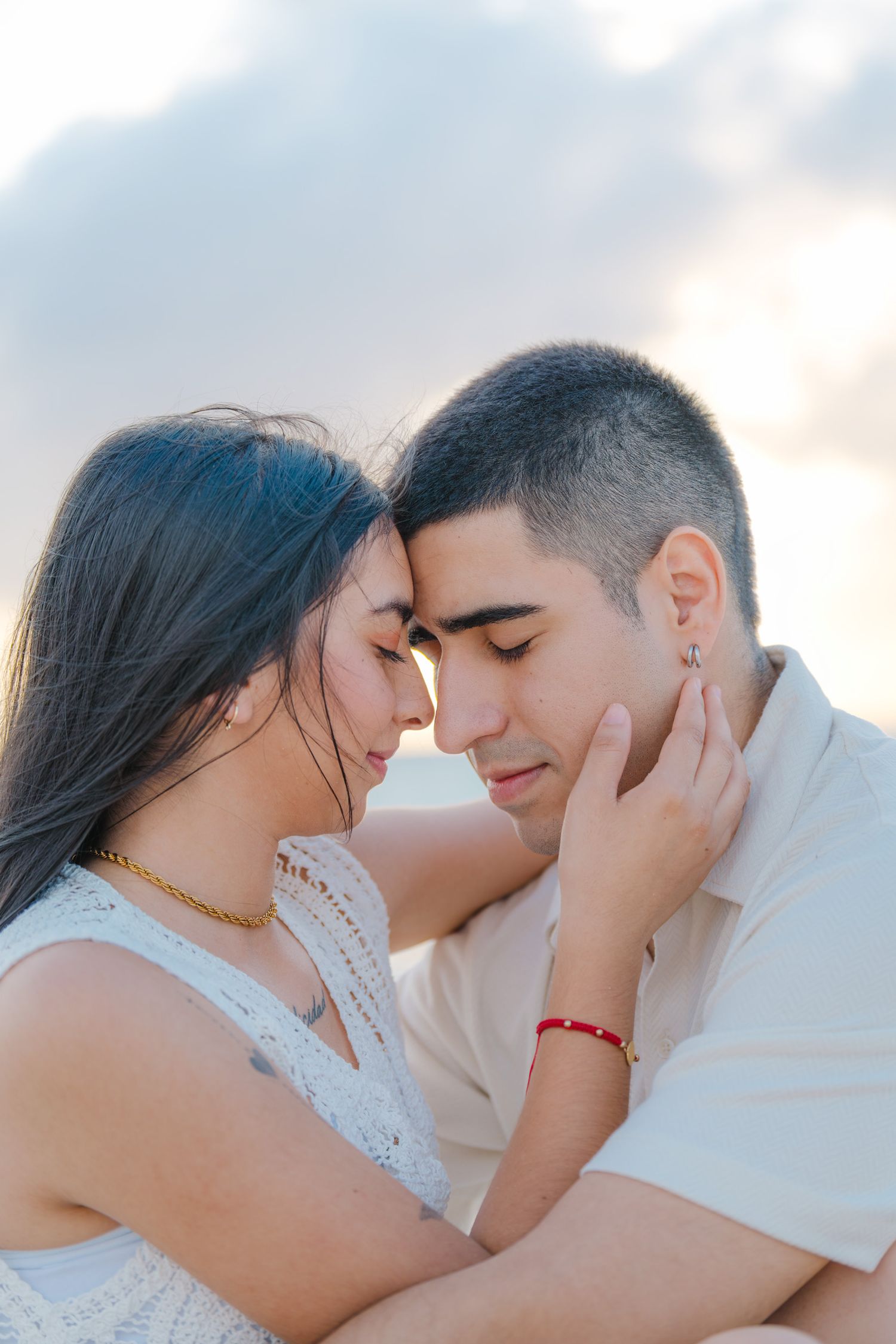 An intimate close-up of a couple sharing a tender moment on the beach.