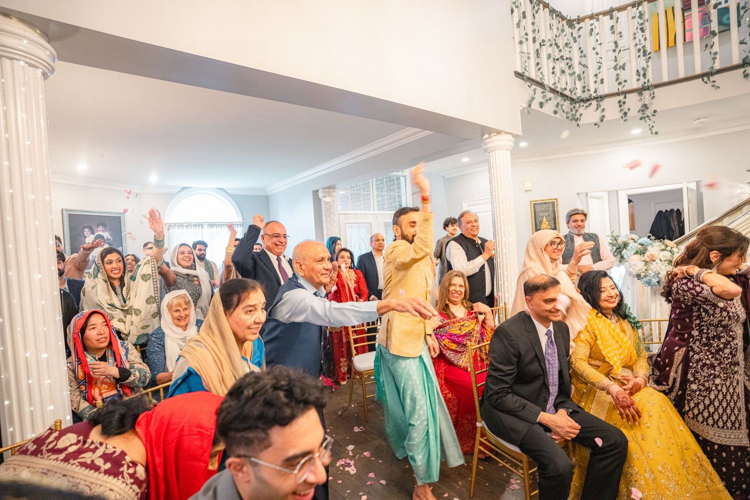 Family throwing flower petals at the new married couples