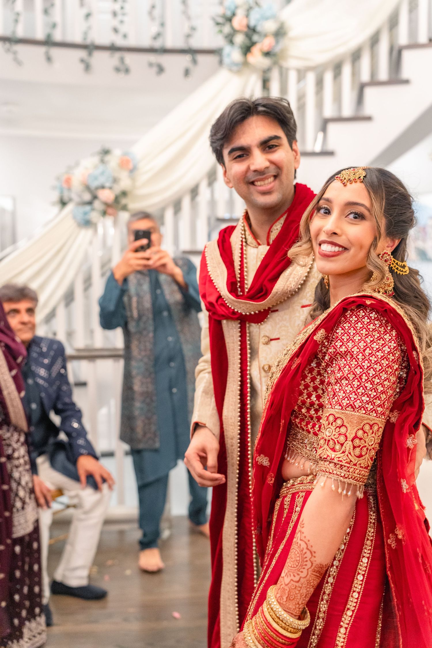 Couples are smiling at their family in heir traditional wedding clothing