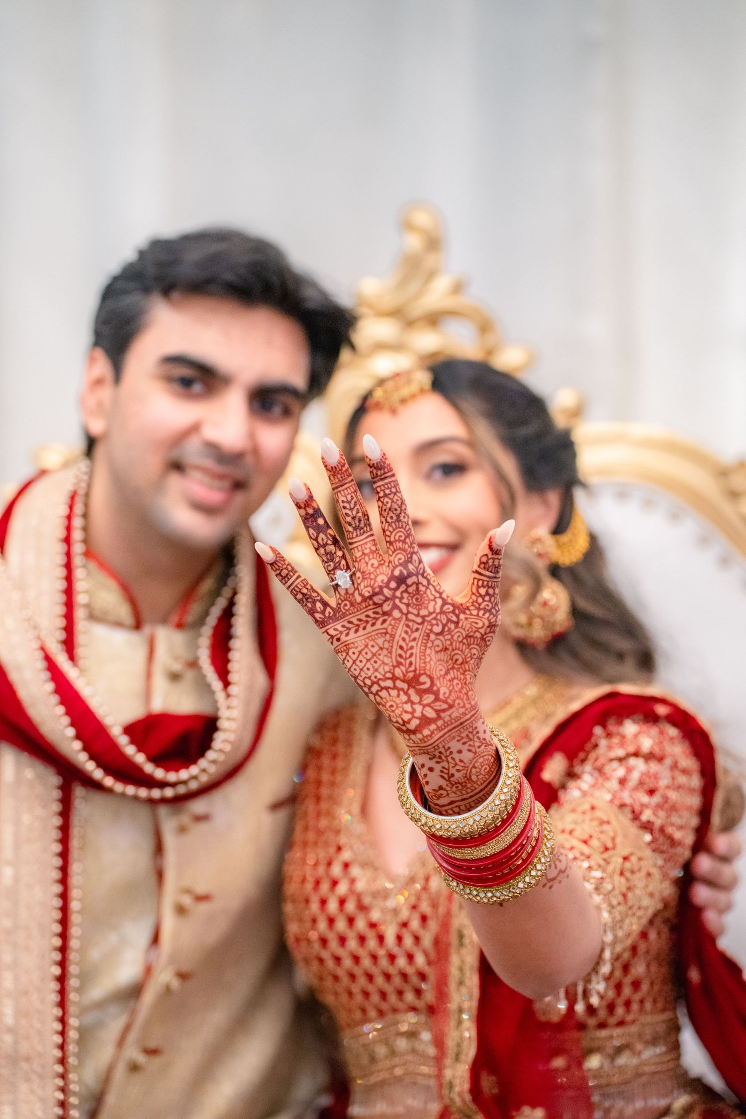 Bride showing off her ring beside the groom in their traditional weedding clothing