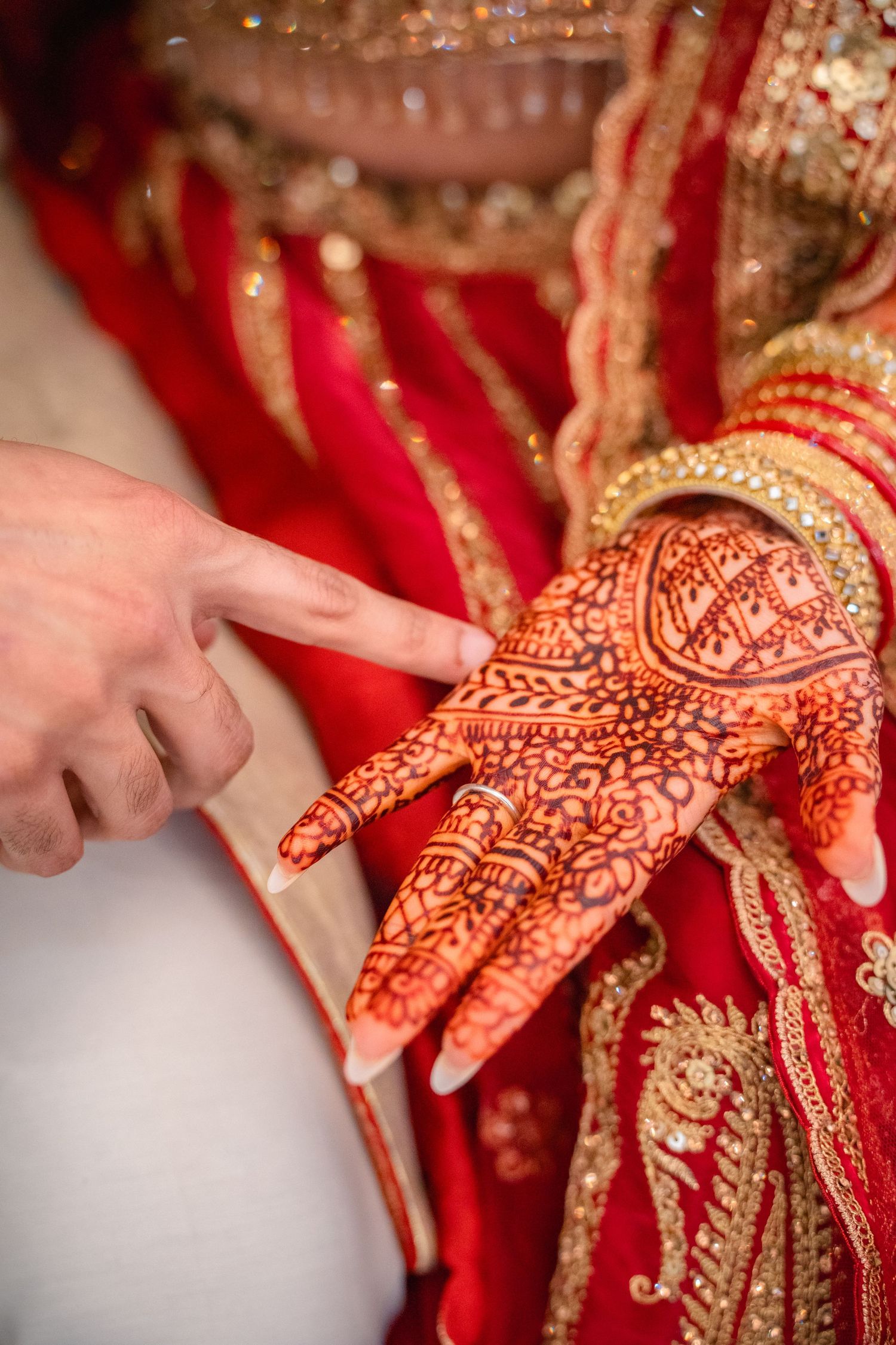 Groom finding his name at Bride's Mehendi in their traditional wedding clothing