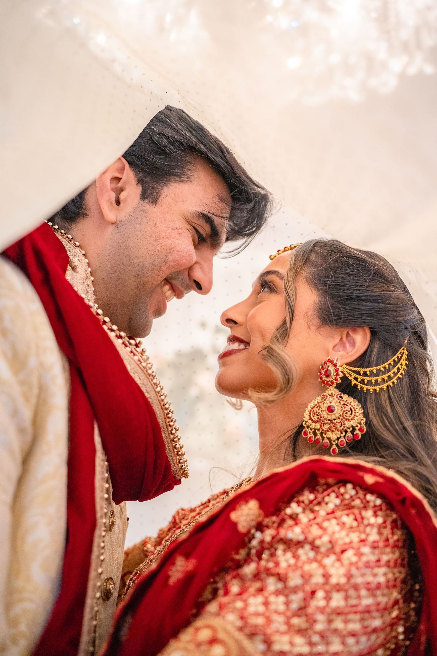 Couples in traditional clothing under a Veil