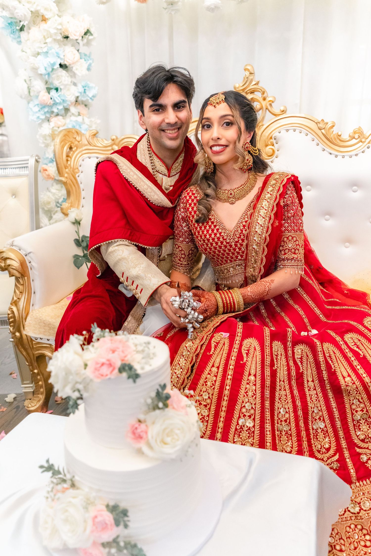 Couples cuttting a cake in their traditional wedding clothing