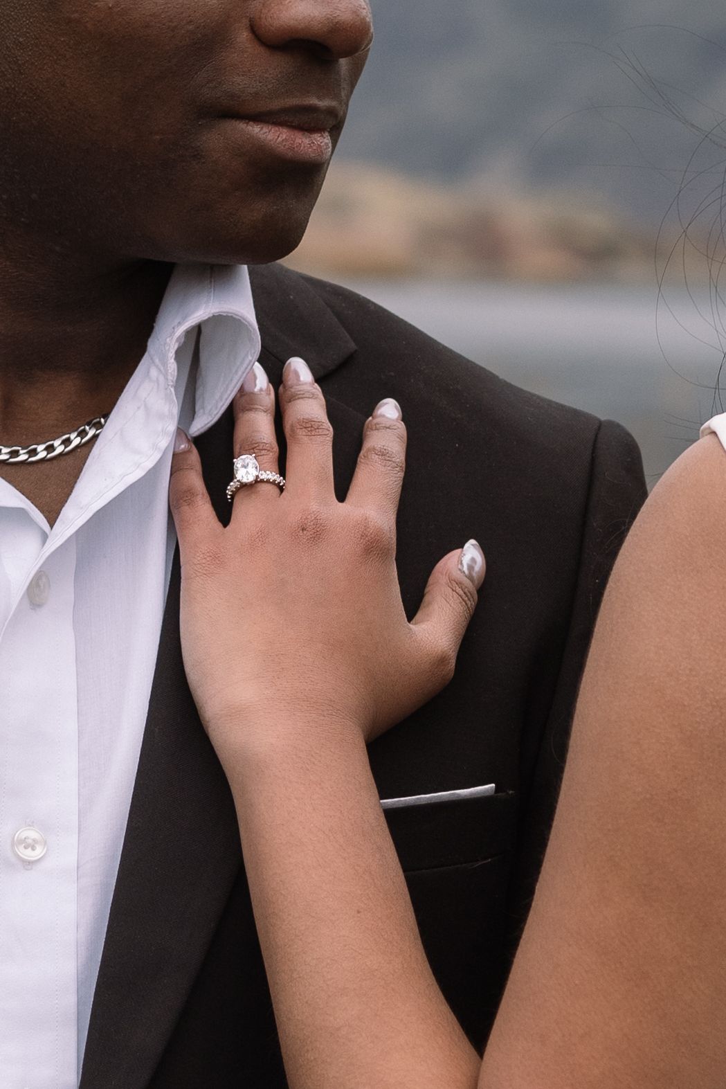 Close-up details of formal wedding attire and jewelry.