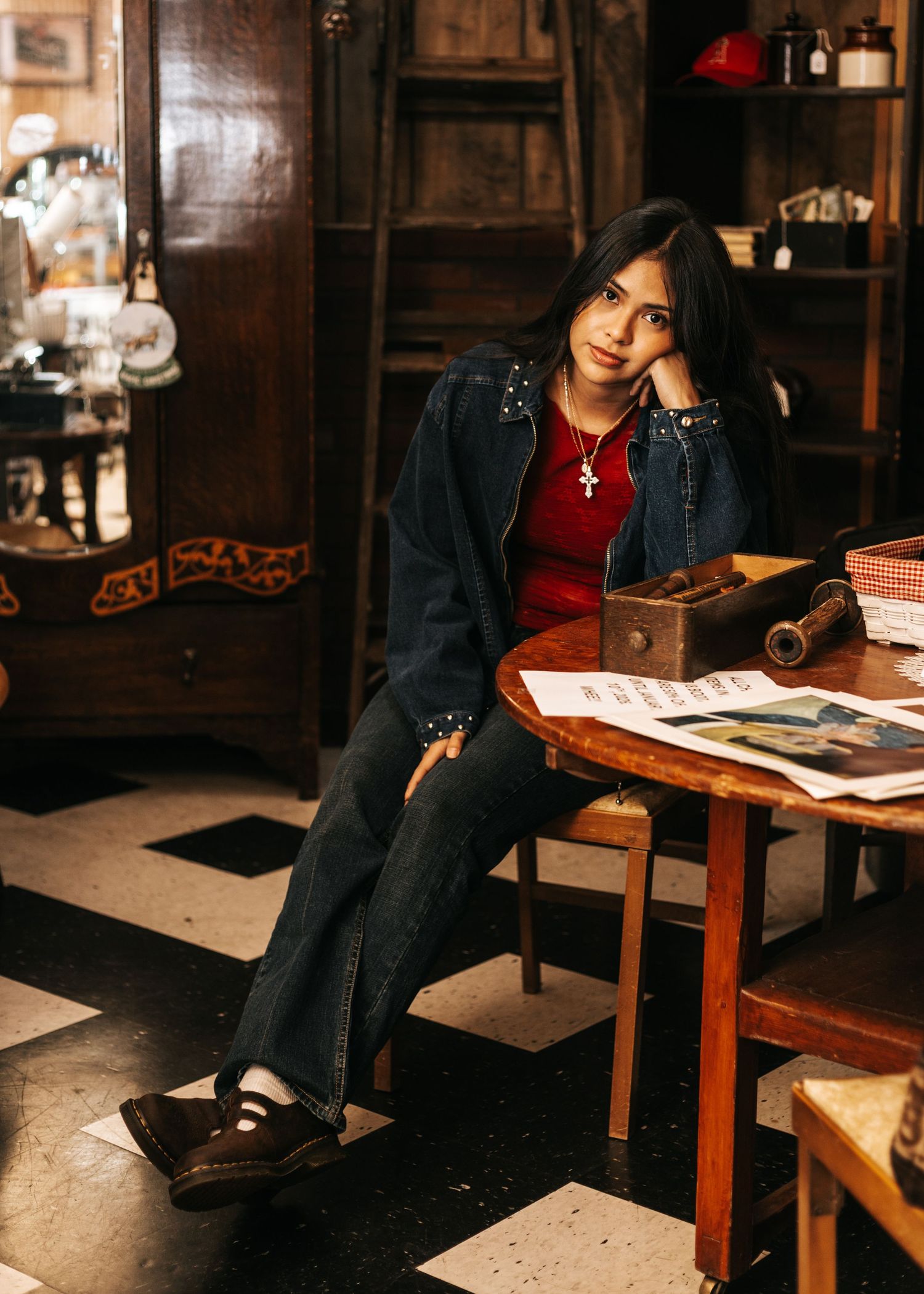 Casual portrait in vintage study room with red top and denim jacket.