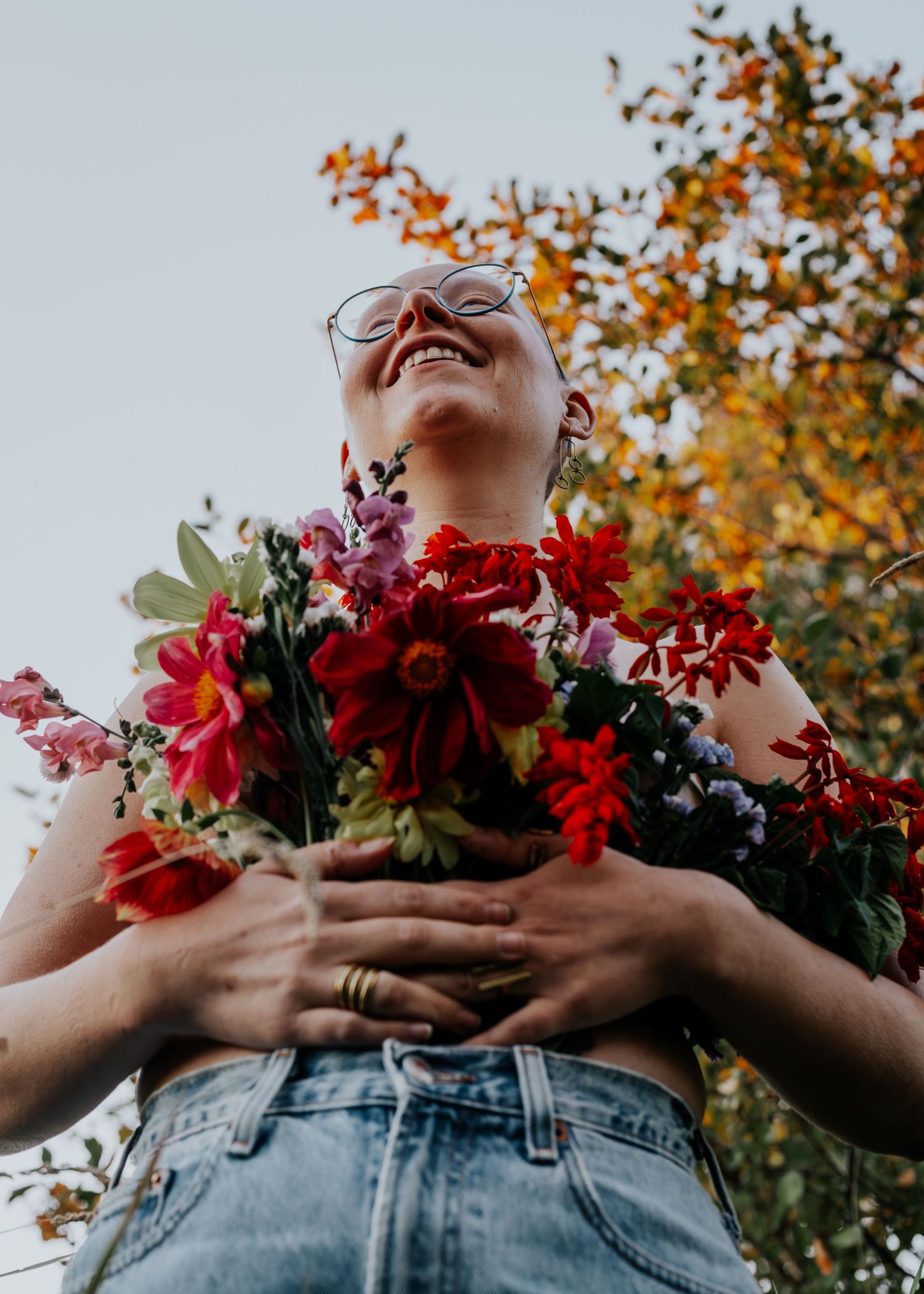 A joyful moment captured with vibrant red flowers against autumn foliage in the background.