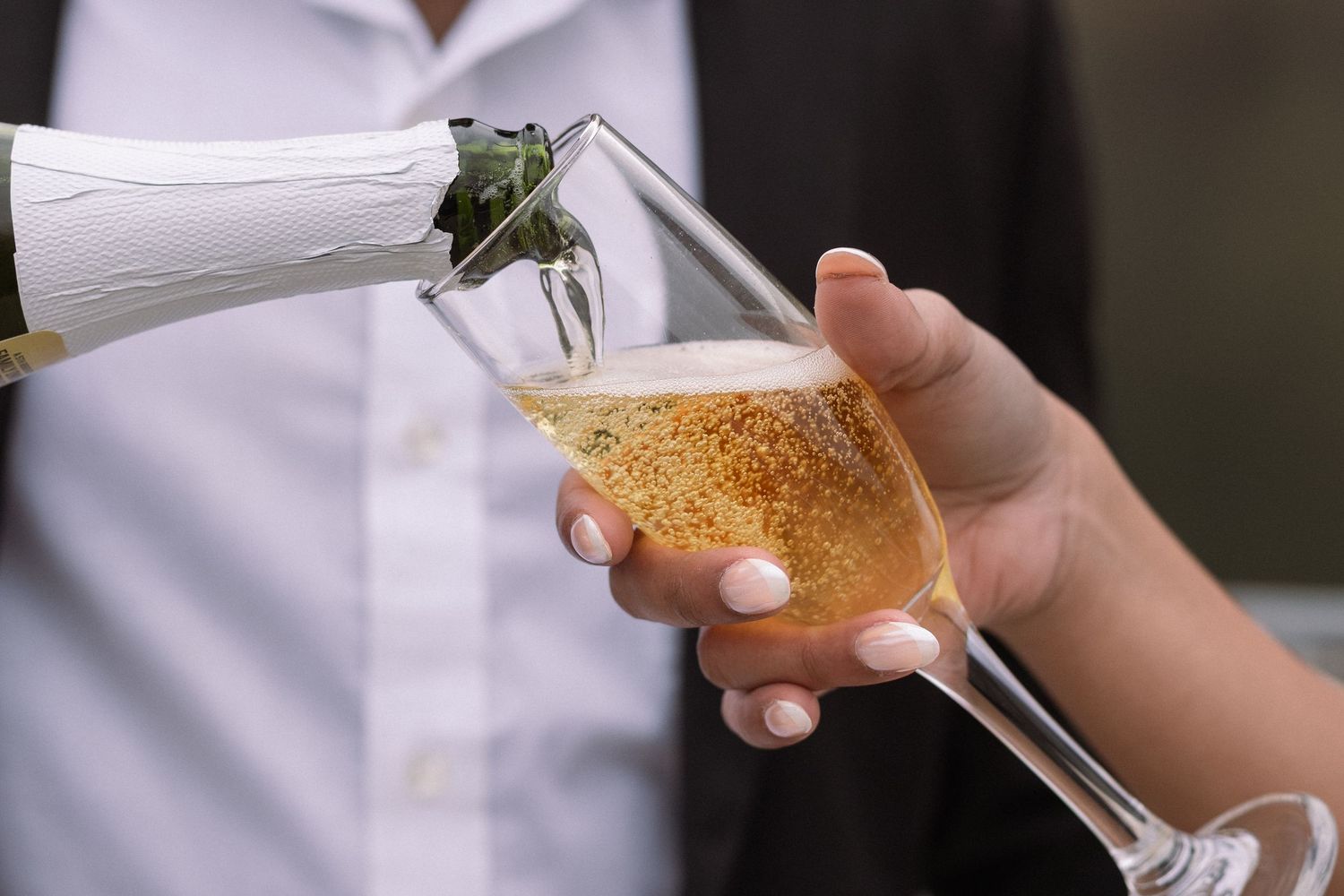 Close-up of champagne glasses being held during a celebration.