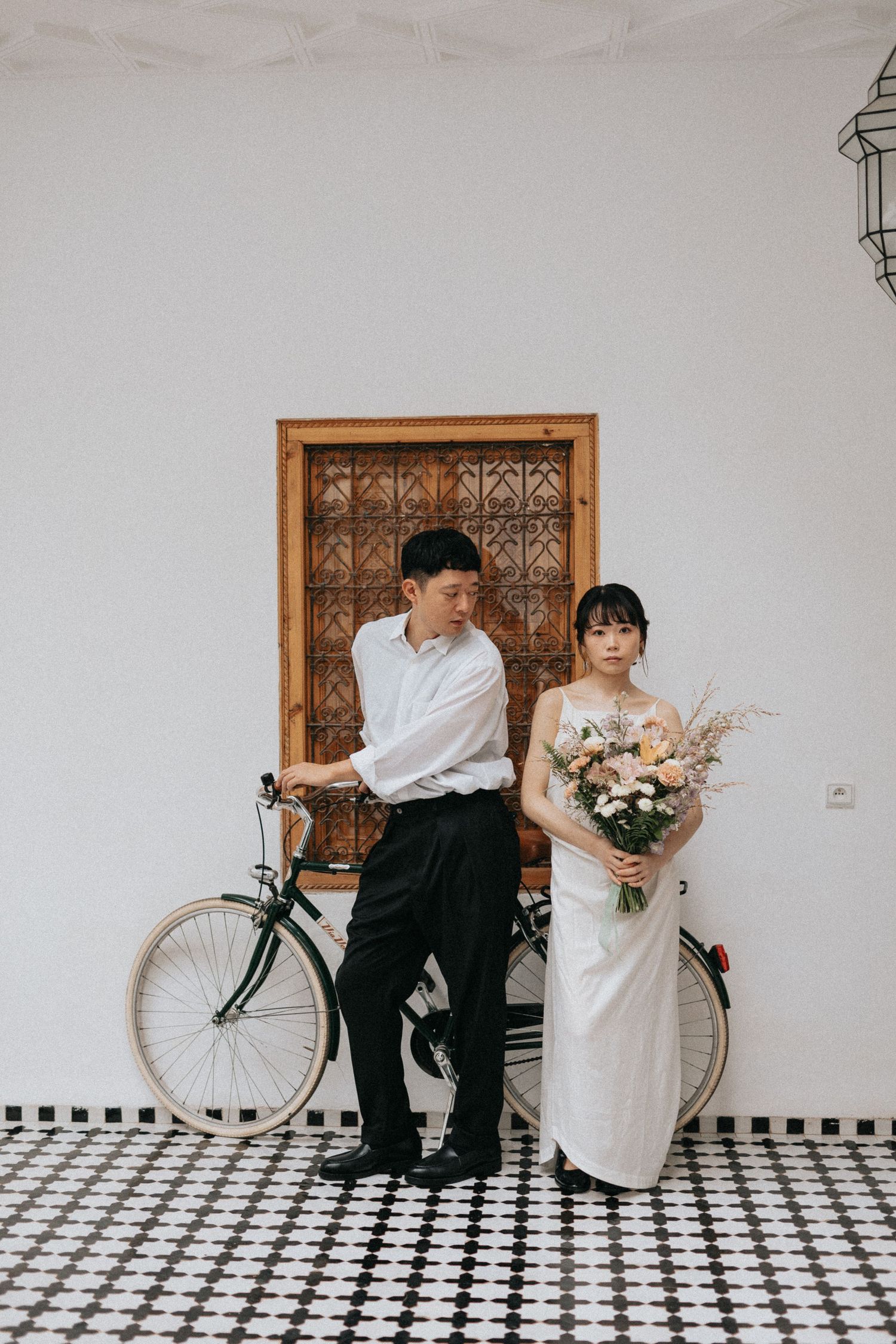 Romantic bridal and groom portrait in a riad with carved cedar doors and vintage decor