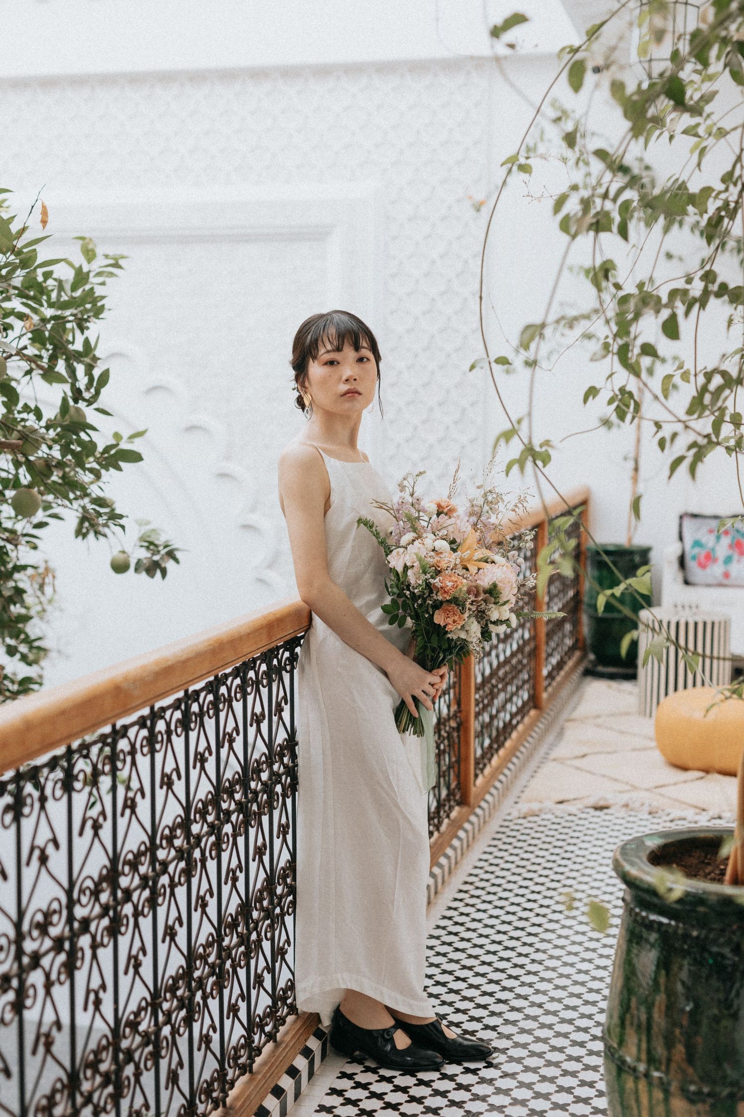 Fine art photo of bride holding bouquet in romantic riad garden setting