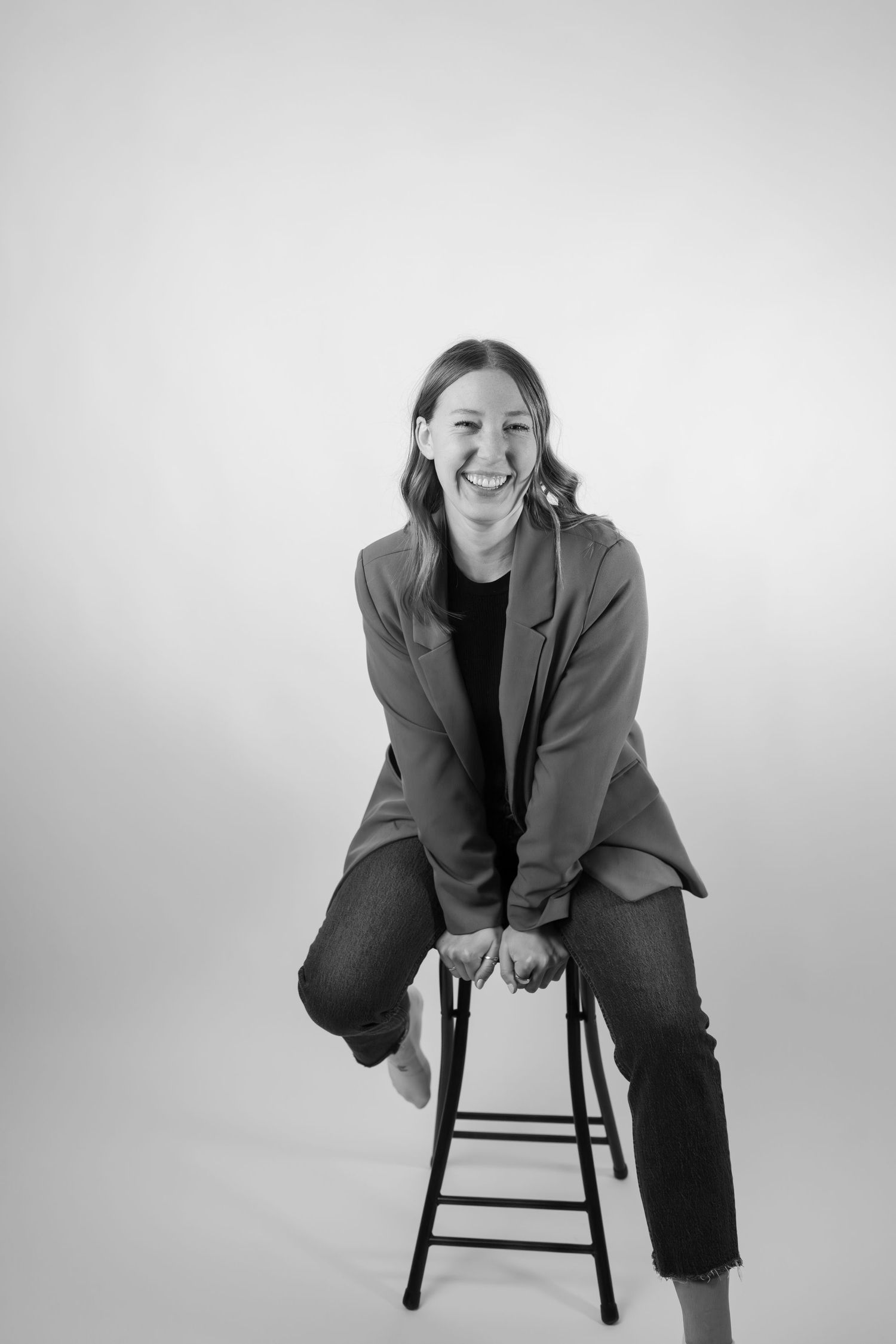 Series of casual poses on a stool showing playful expressions against white backdrop.