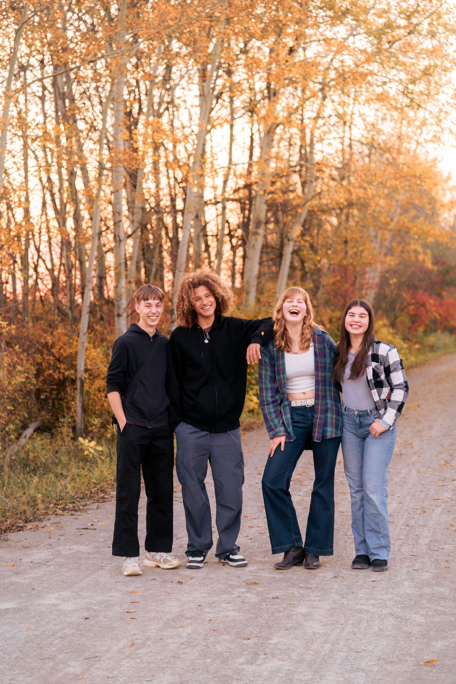 Group photo of family members standing together on autumn forest path.