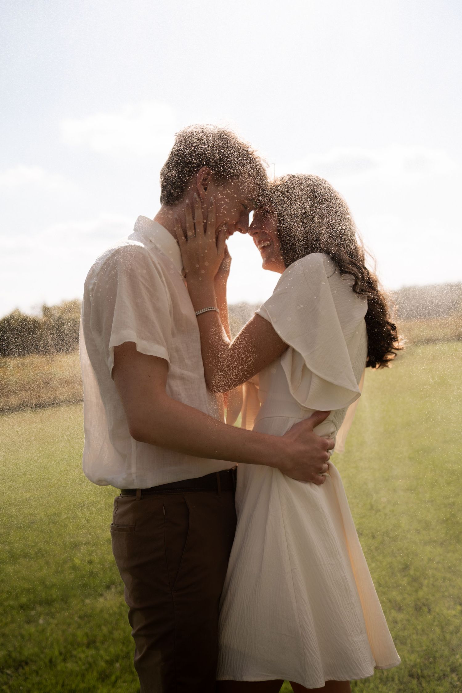 Dreamy outdoor portrait of couple sharing an intimate embrace in golden light.