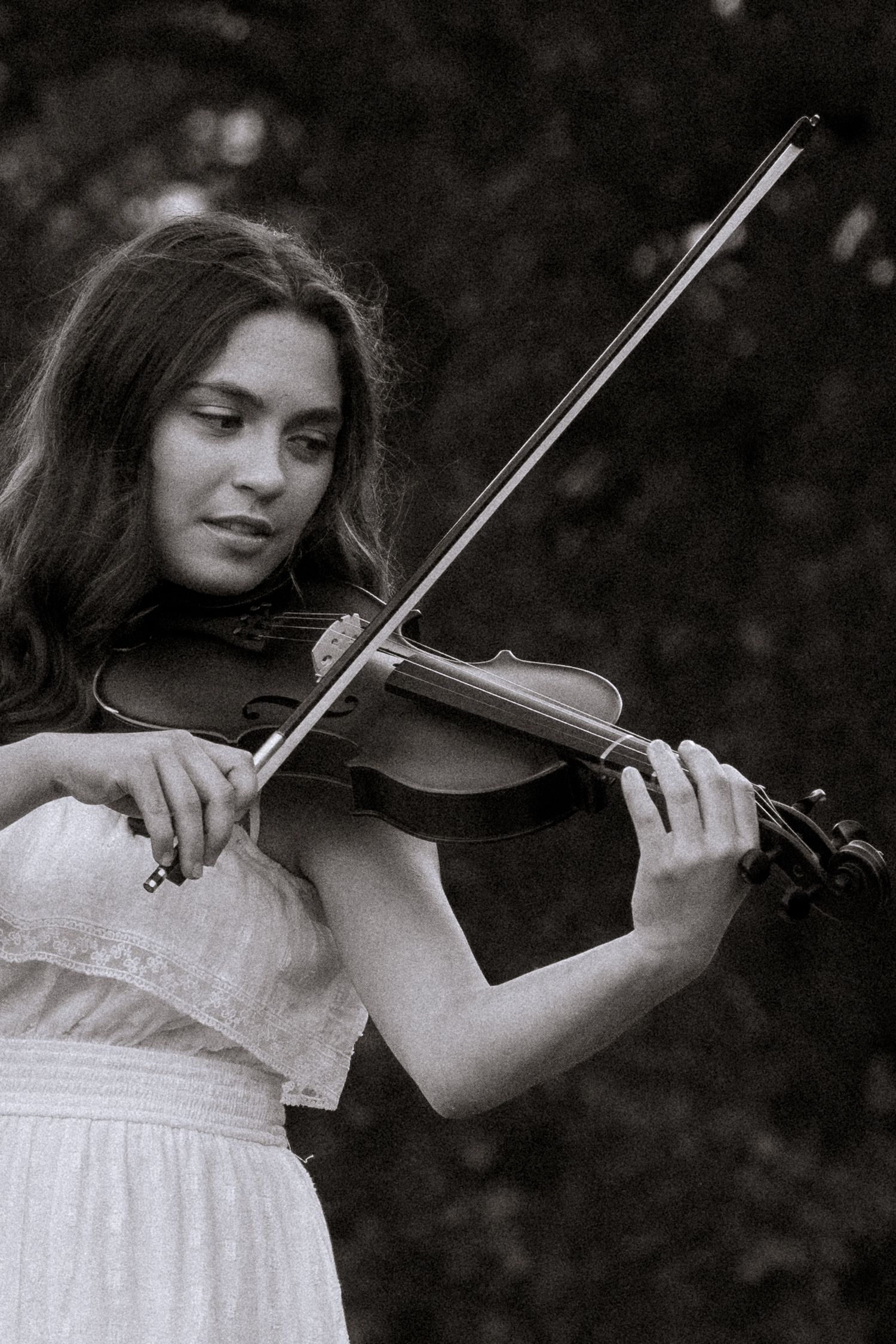 Black and white portrait series of someone playing violin in a white dress.
