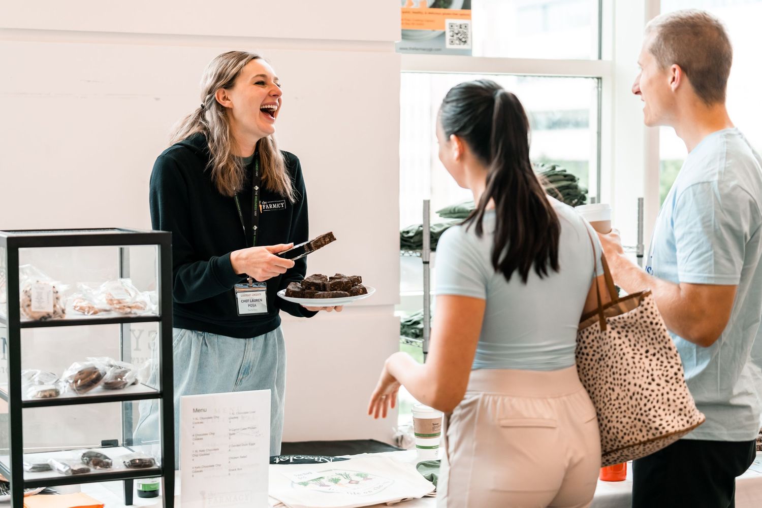 People interacting at a bright modern cafe or meeting space with casual seating.
