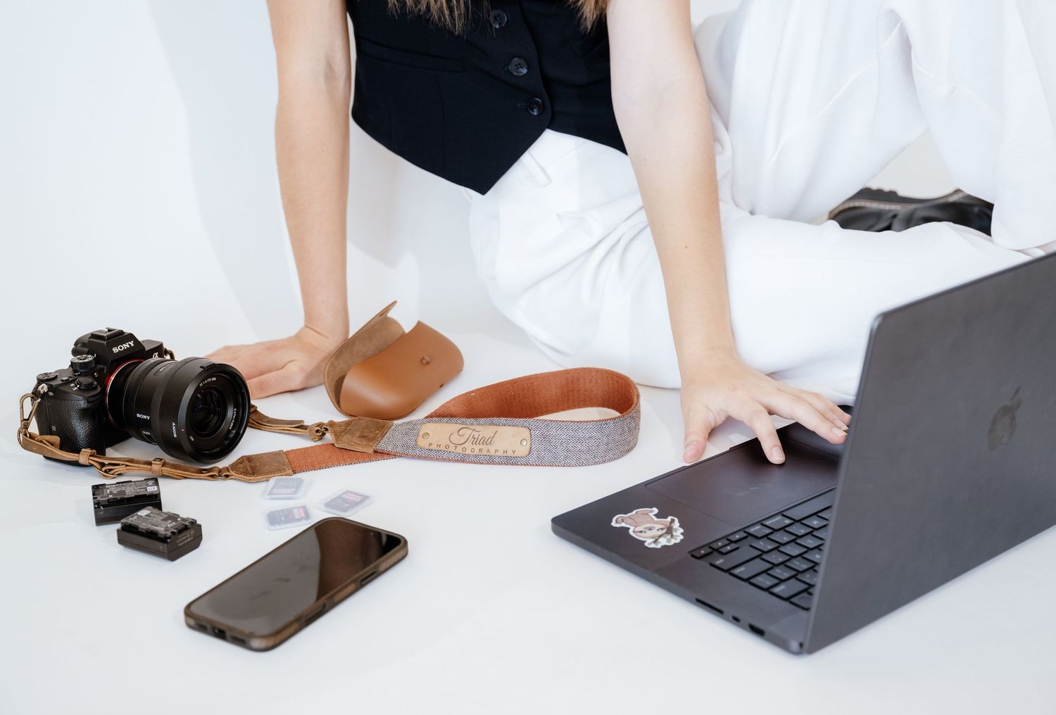 Person working with laptop and phone on white surface showing various resting positions.