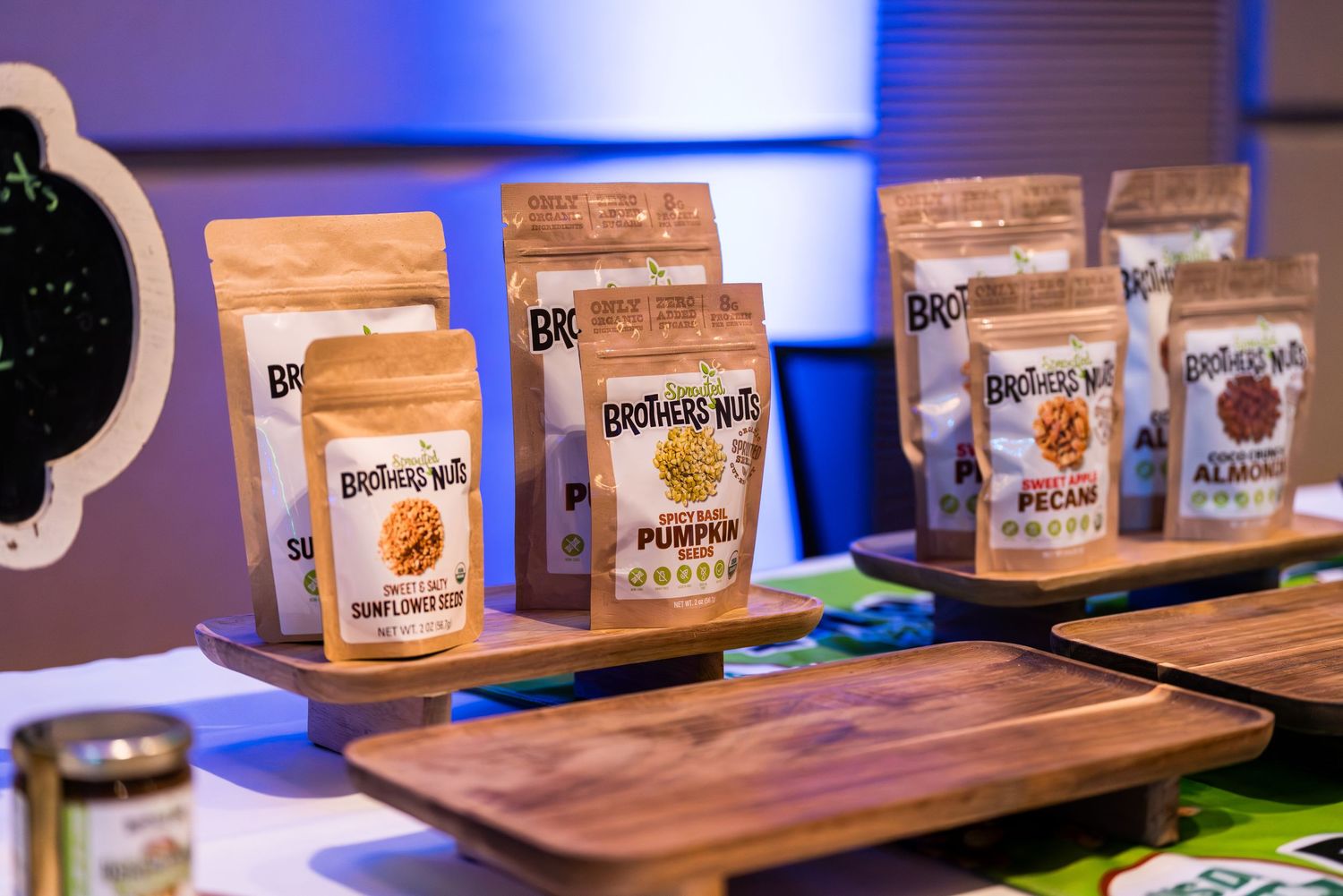 Wooden display showcasing packaged protein powder products with blue lighting.