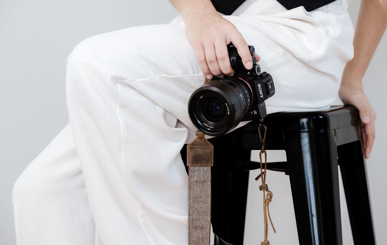 Professional camera equipment arranged on white surface showing lenses and tripod.