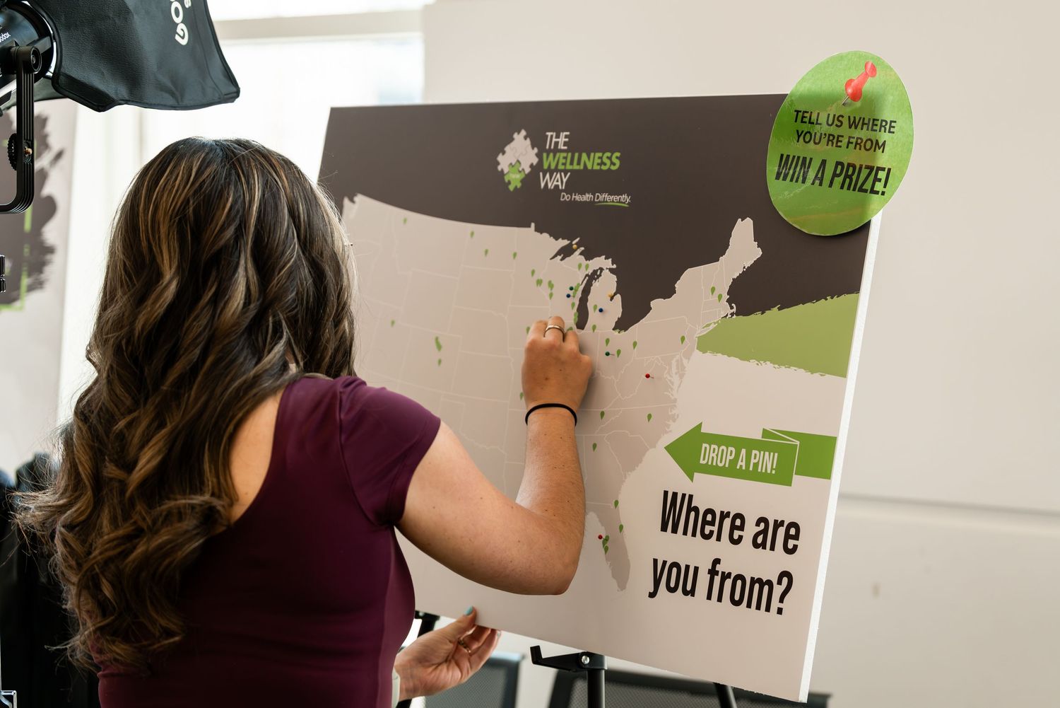 Someone pointing at a location on a brown state map display board.