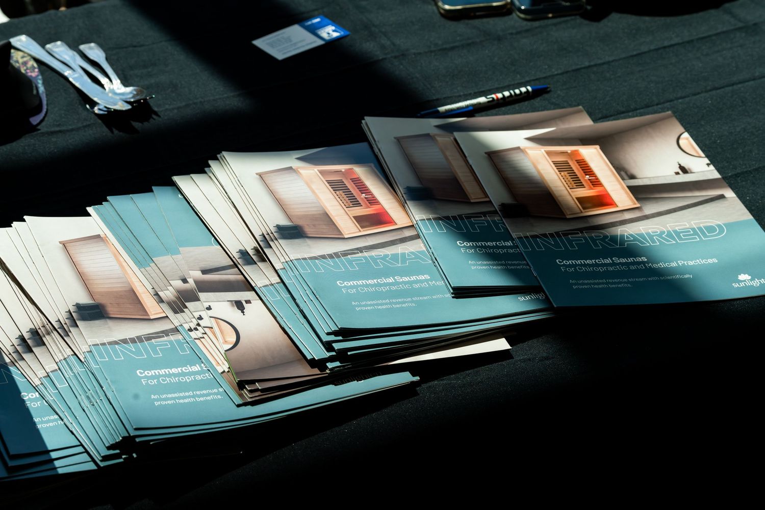 Marketing brochures and promotional materials laid out on a dark surface.