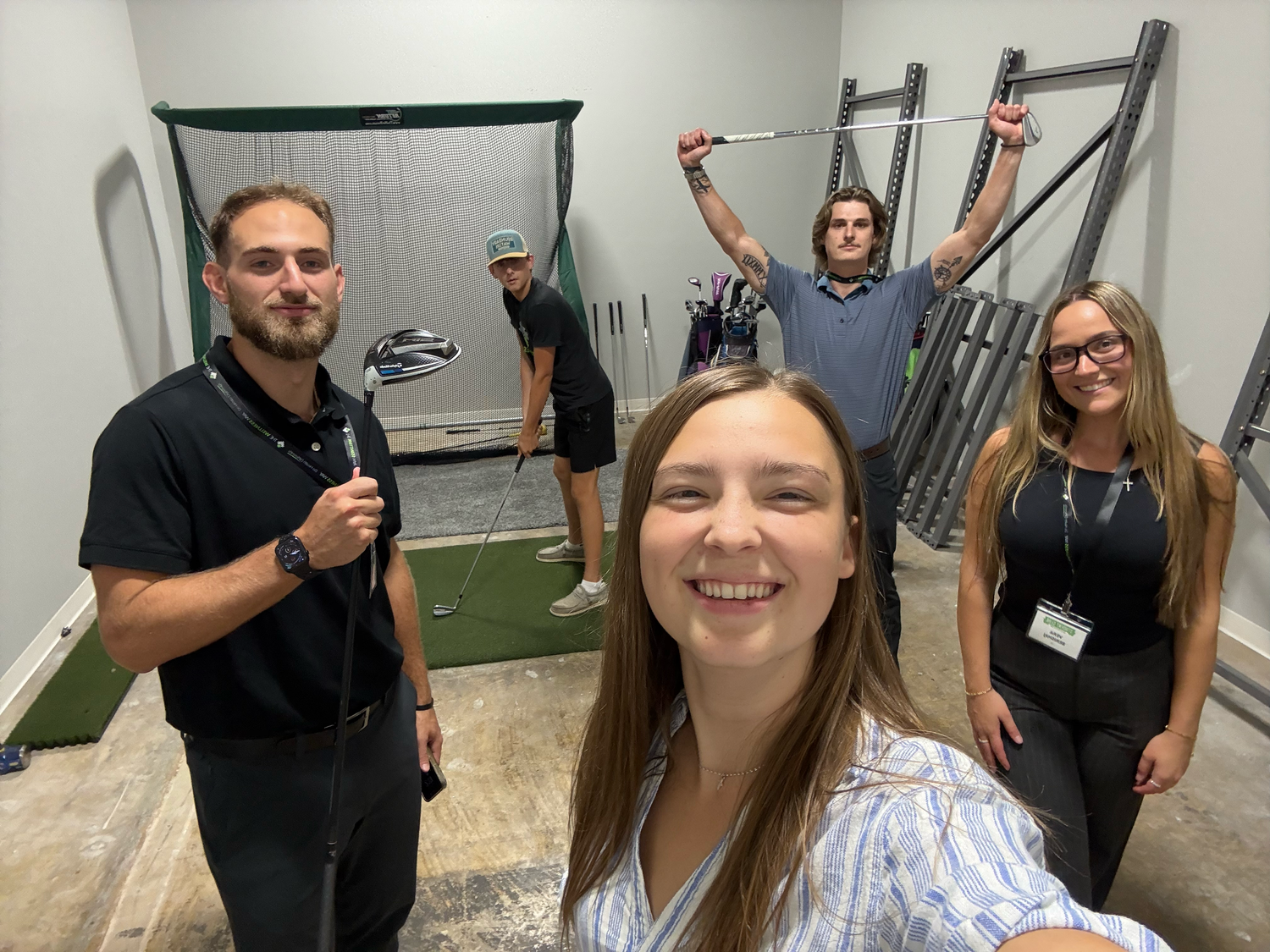 A group poses for a fun selfie in what appears to be a fitness or training facility.