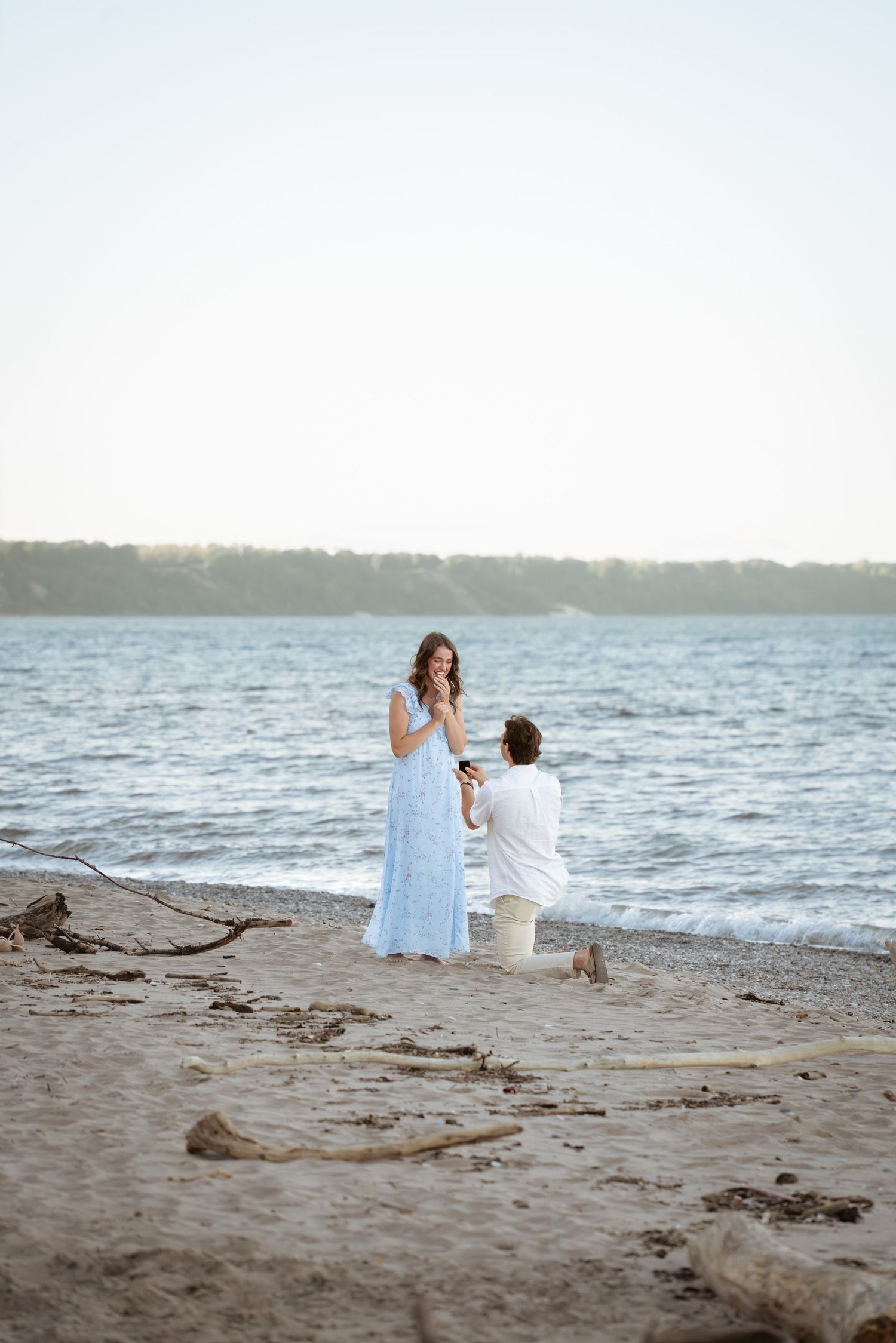 Romantic beach scene with white dresses against the ocean at sunset.