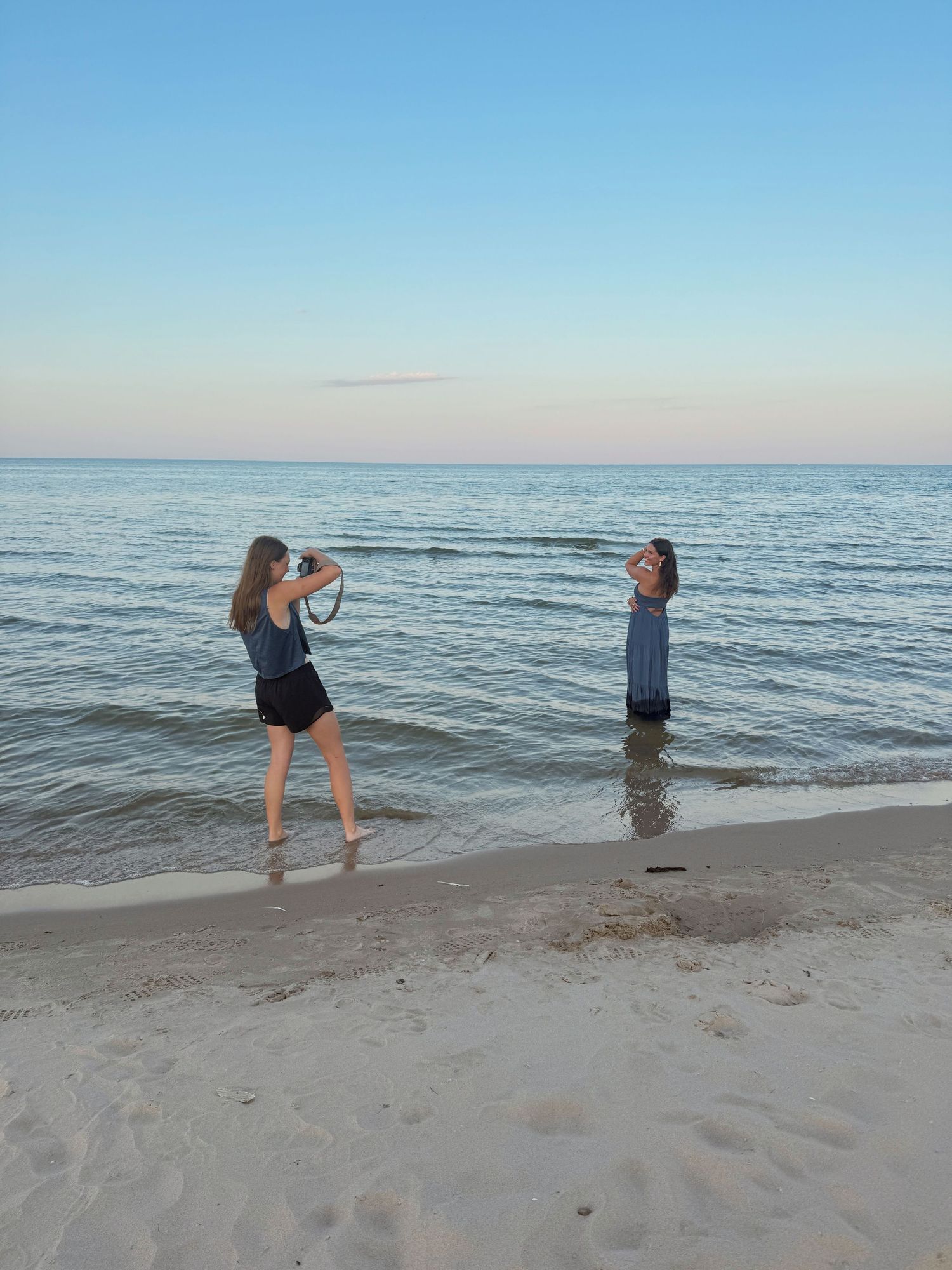People playing and splashing in shallow ocean water at the beach.