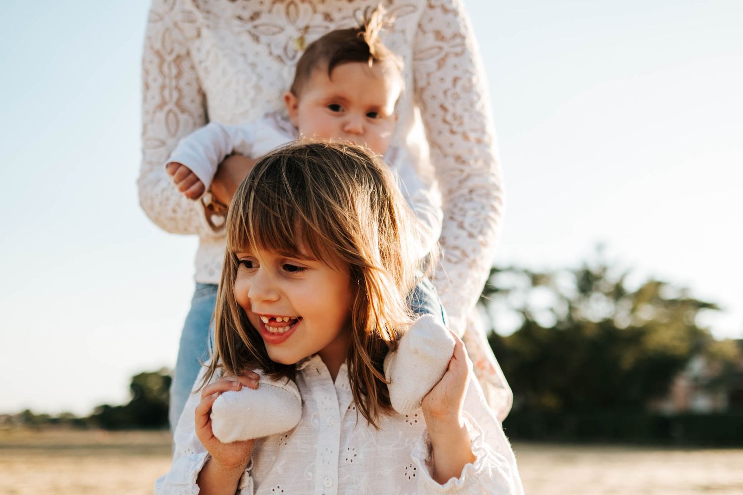 Candid outdoor family photos captured during golden hour with natural expressions.