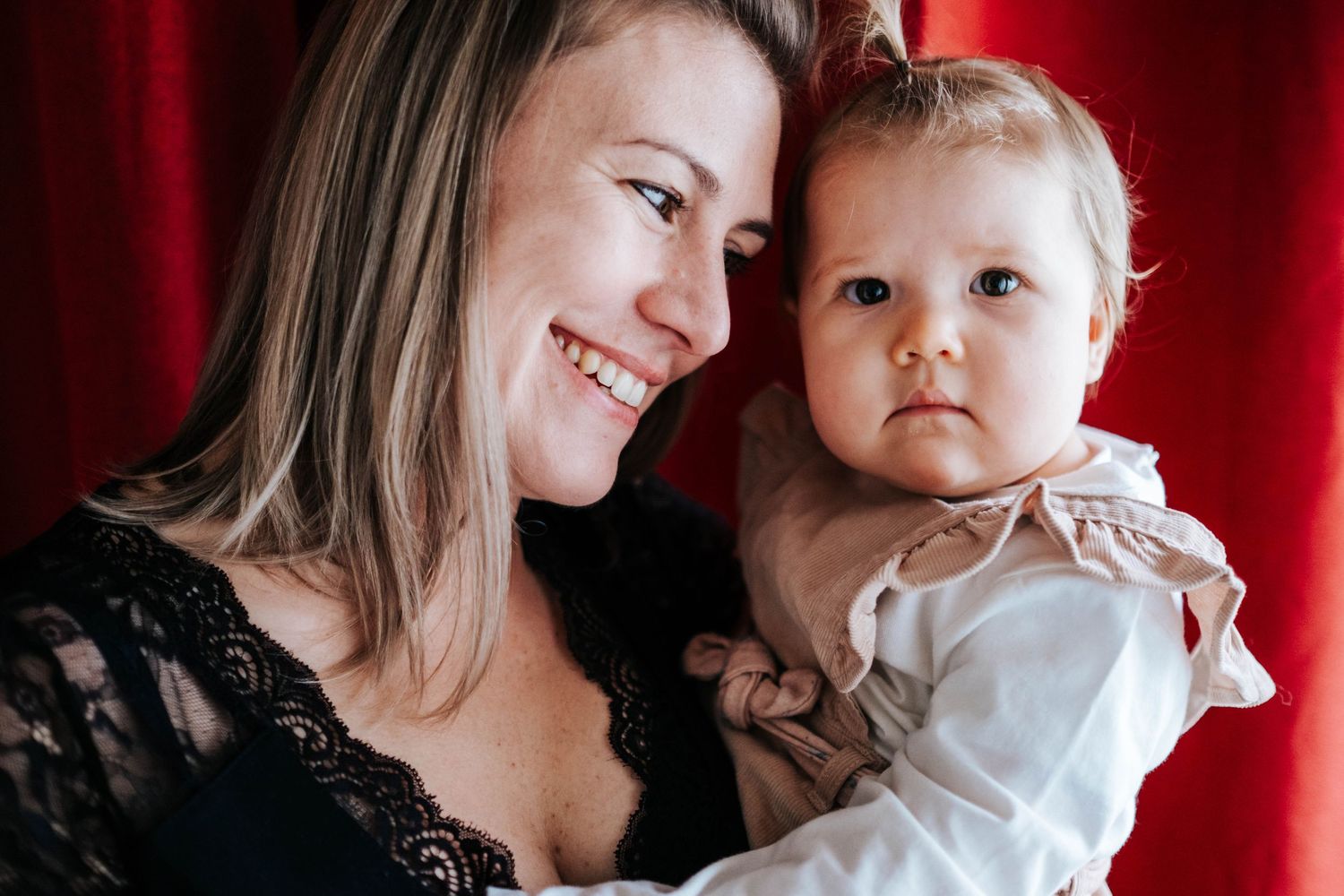 A tender moment between parent and child against a vibrant red background in a series of connected photos.