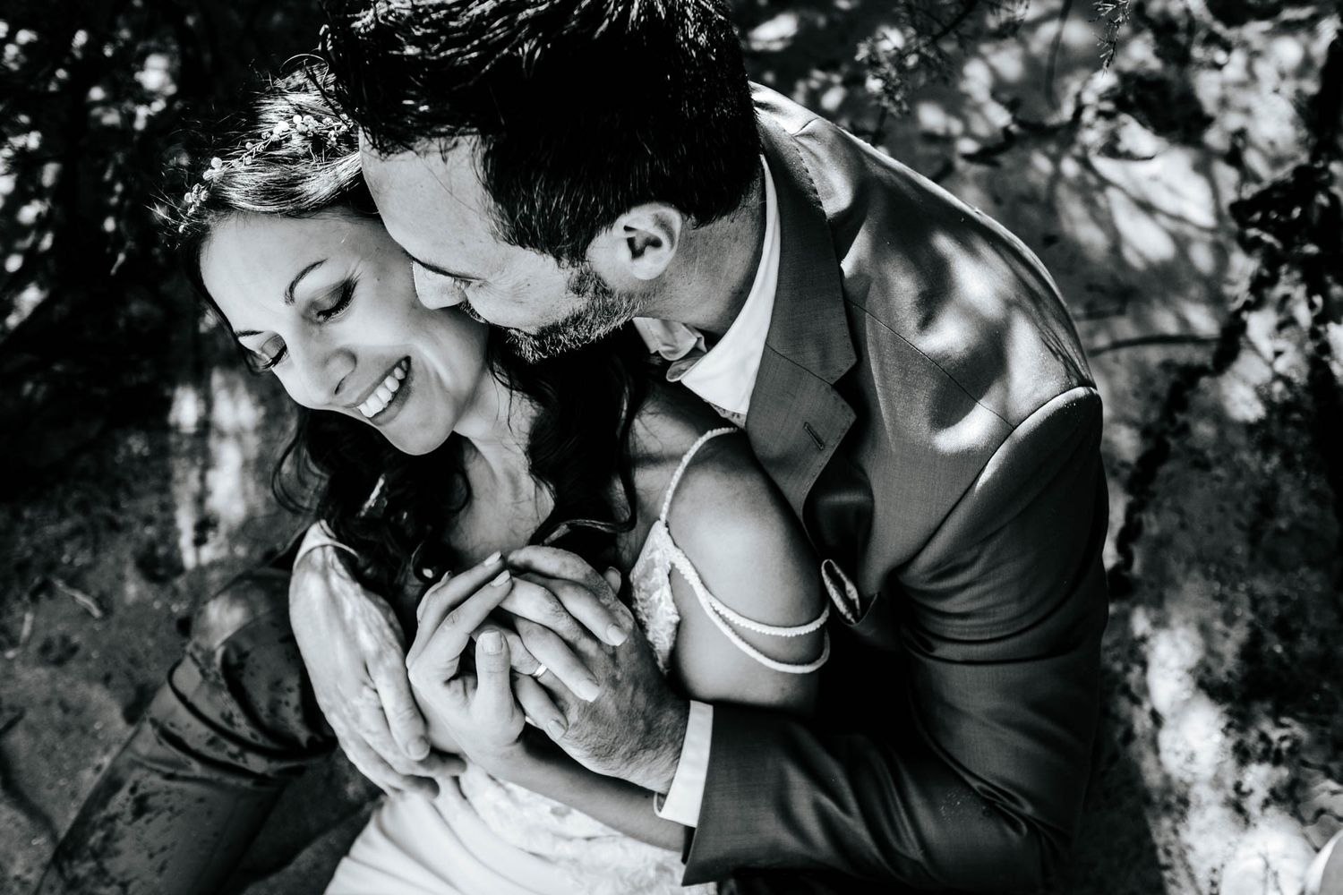 Black and white wedding photography capturing candid laughter and romantic moments.